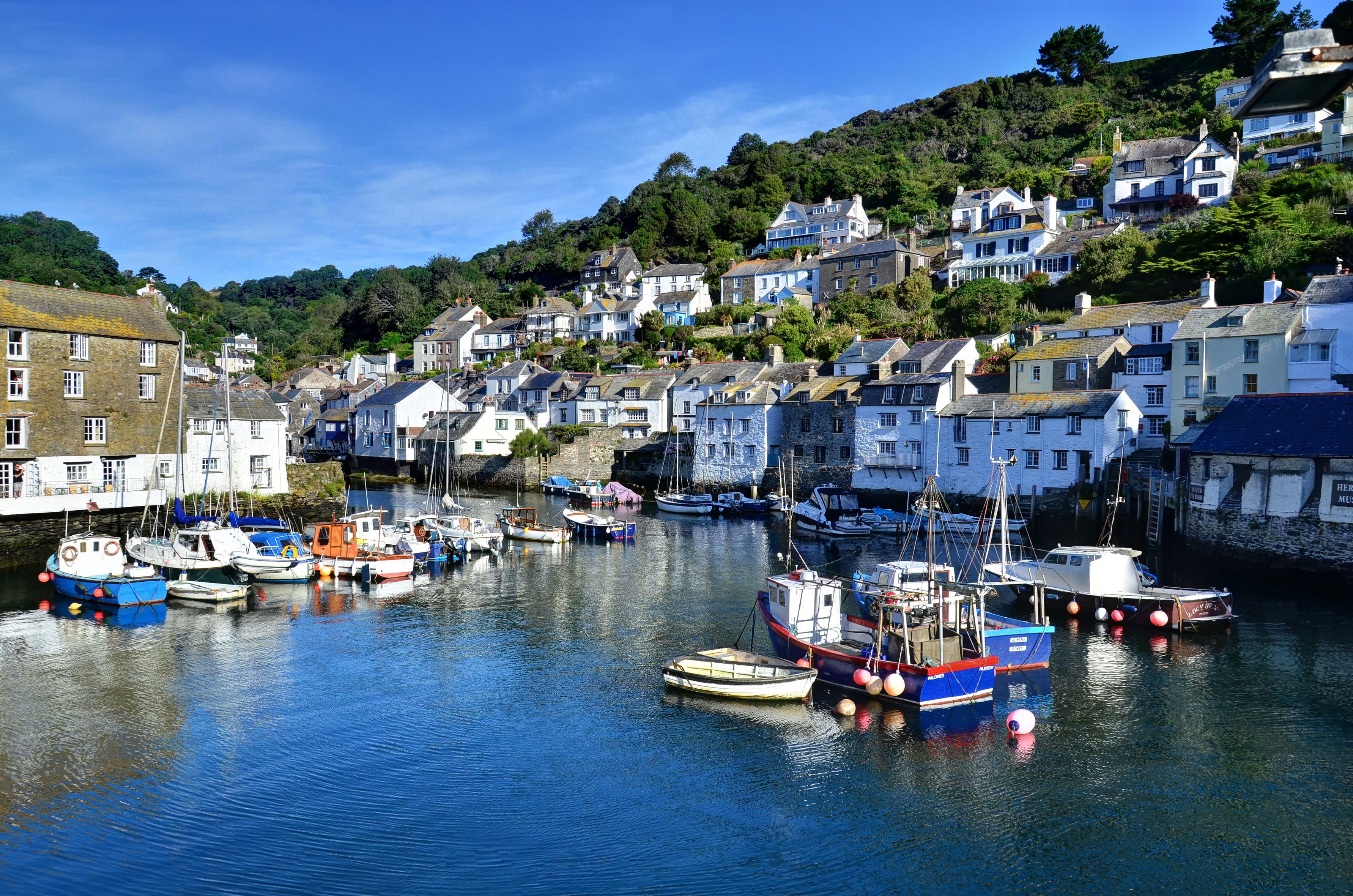 Boats in a harbor with houses on a hill in Polperro, Cornwall HD Wallpaper
