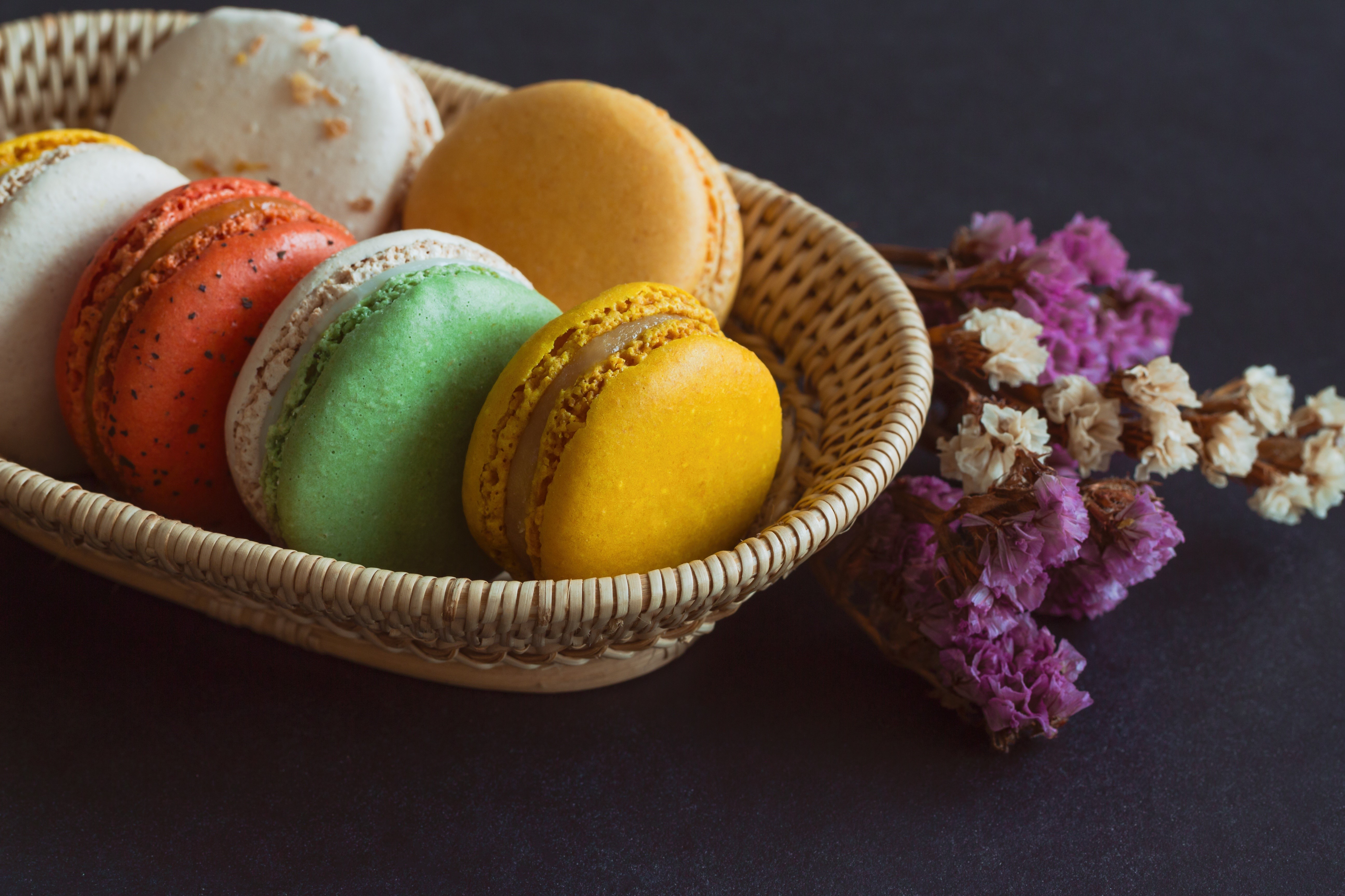 Assortment of colorful macarons in a basket HD Wallpaper