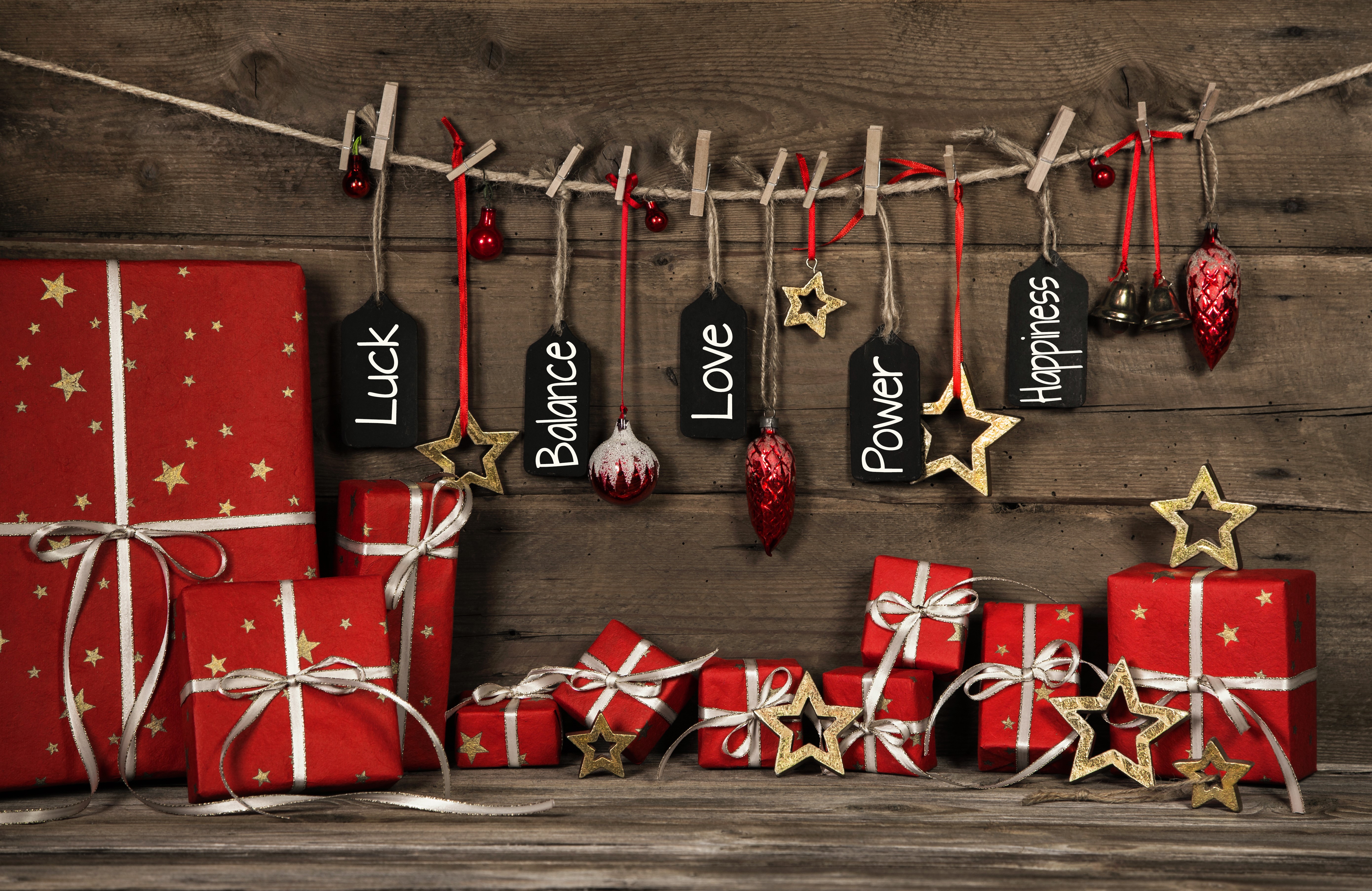 Christmas gifts with inspirational tags on wooden background HD Wallpaper