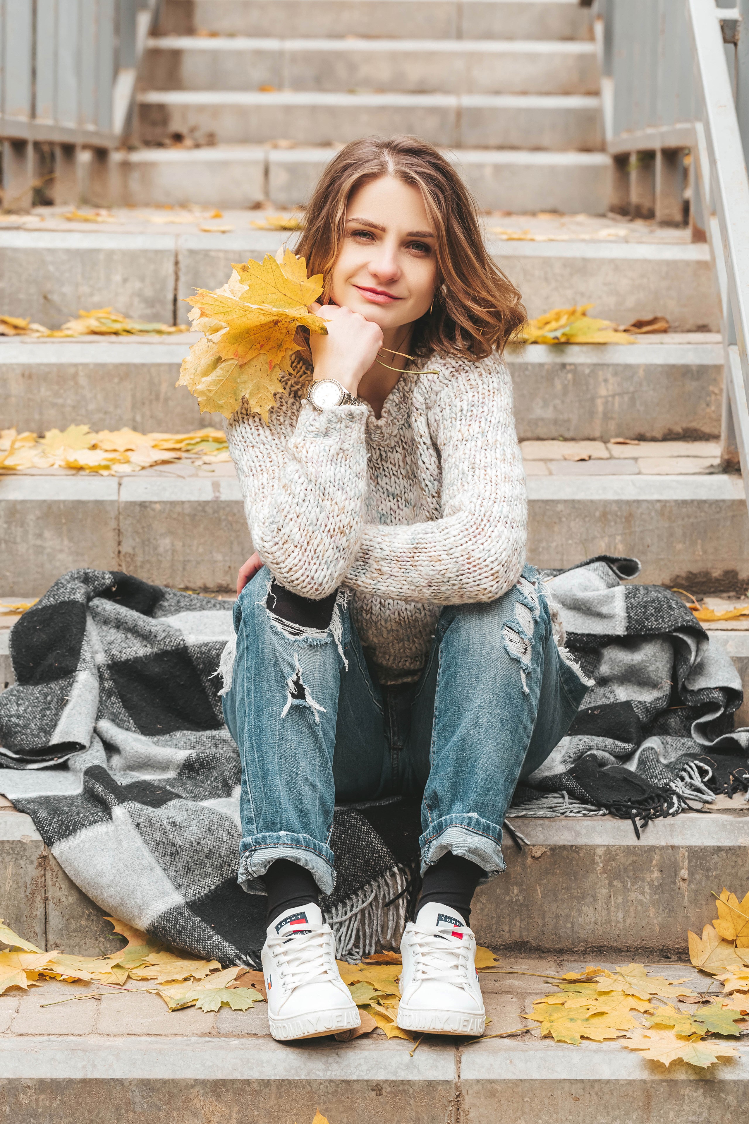 Woman in Sweater and Jeans Sitting on Stairs with Autumn Leaves HD Phone Wallpaper