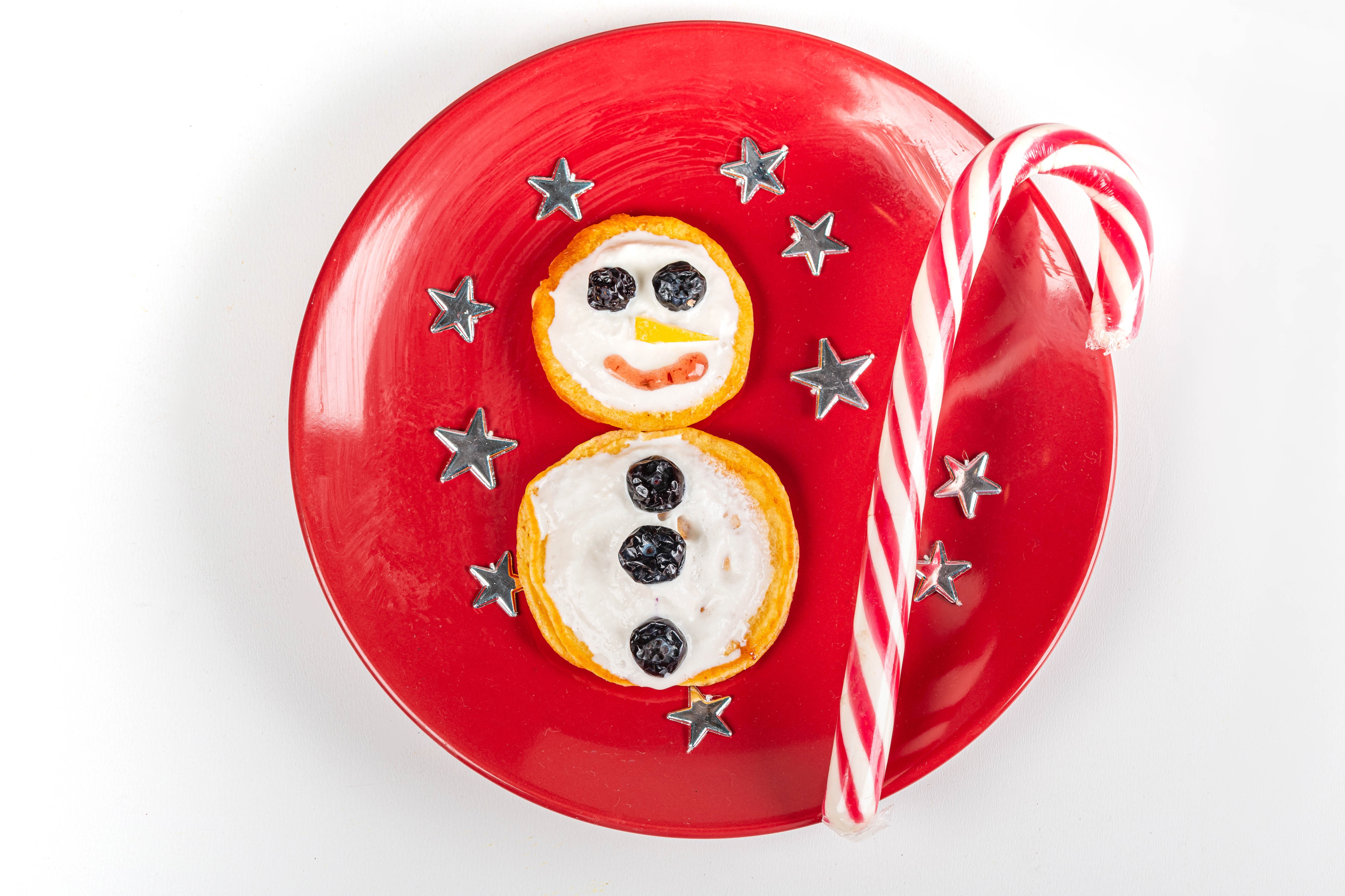 Christmas pancake snowman with candy cane on red plate HD Wallpaper