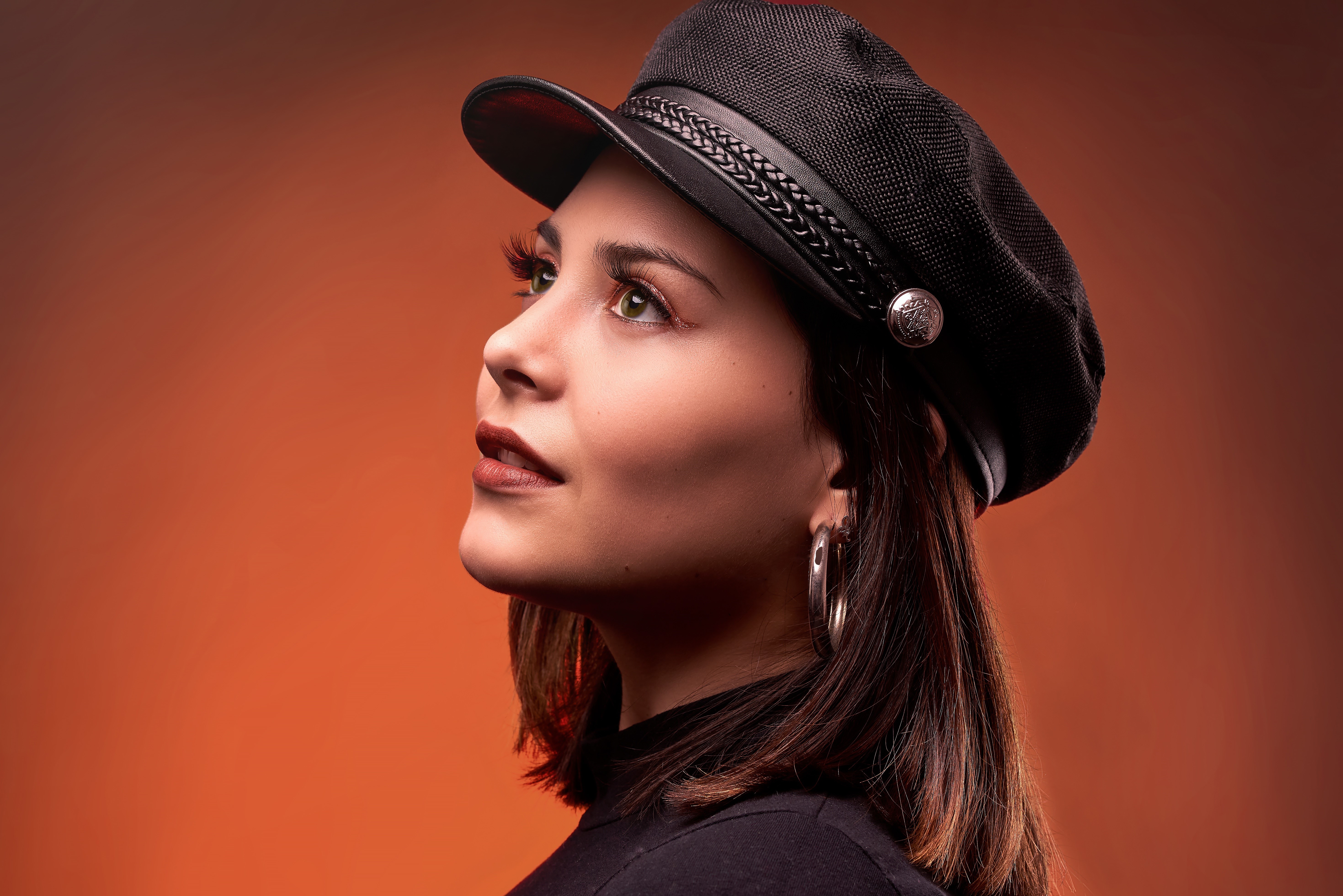 Woman wearing a black baseball cap and hoop earrings HD Wallpaper