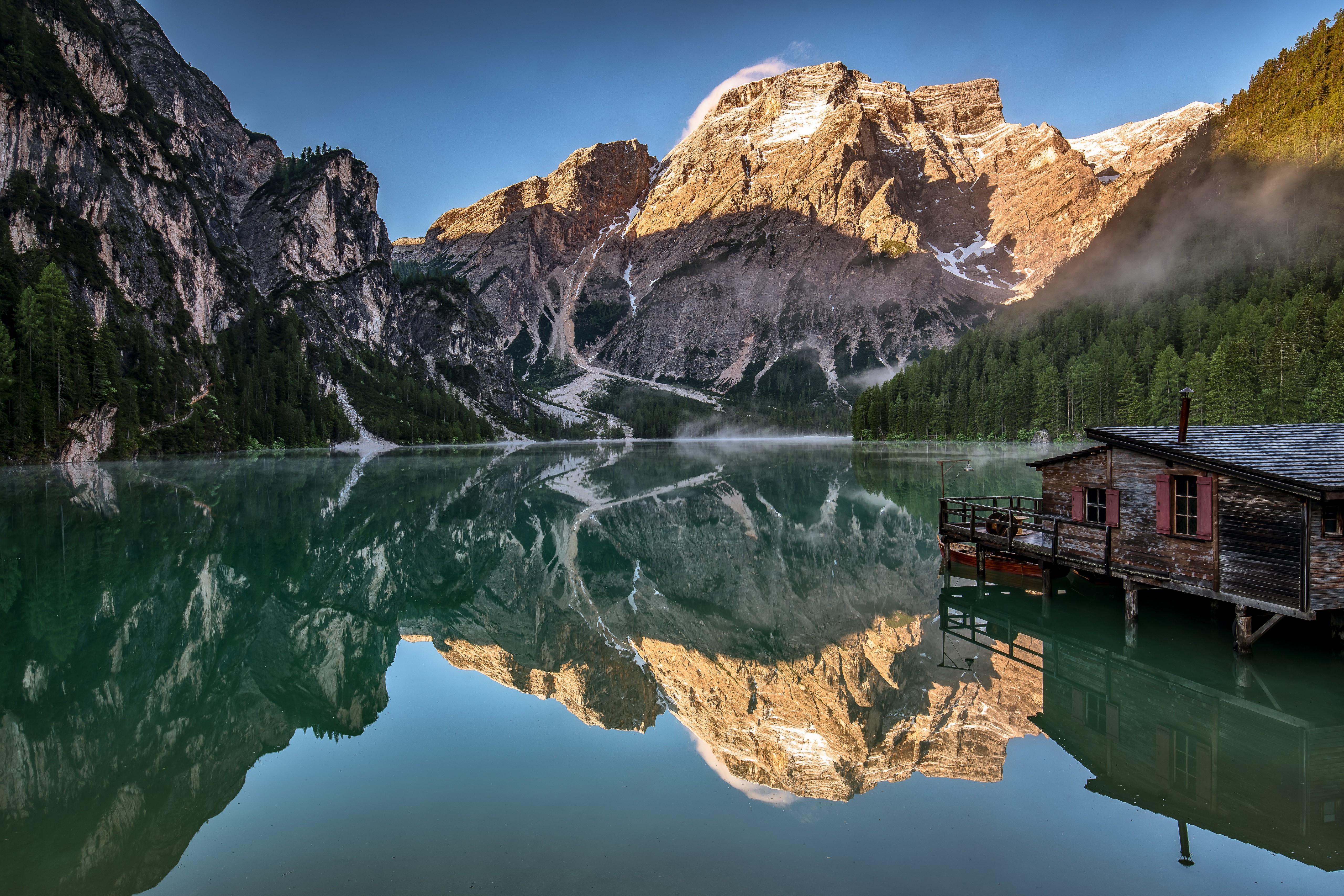Mountains reflected in a lake with a boathouse, Dolomites, Italy HD Wallpaper
