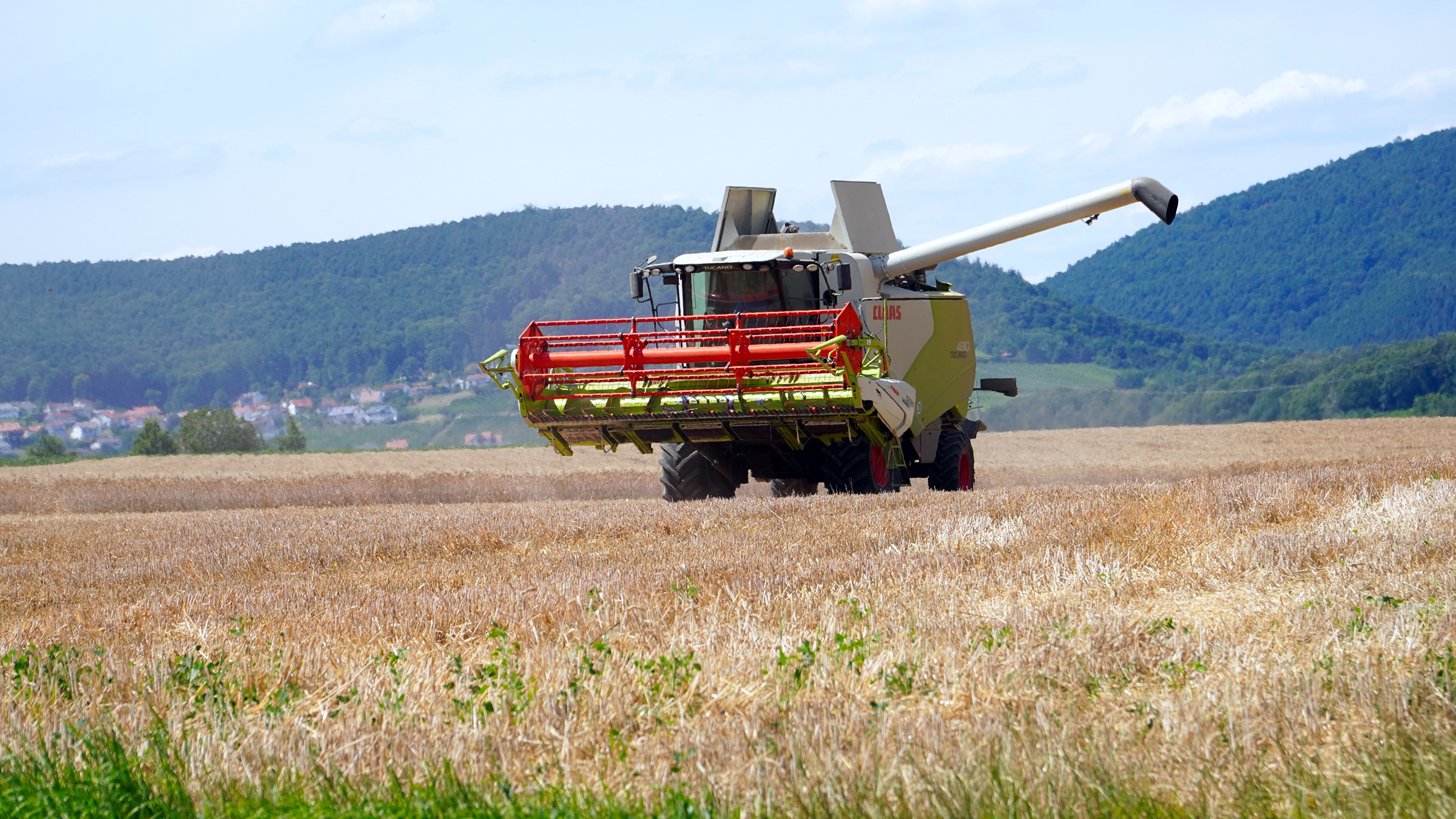 Combine harvester in a wheat field HD Wallpaper