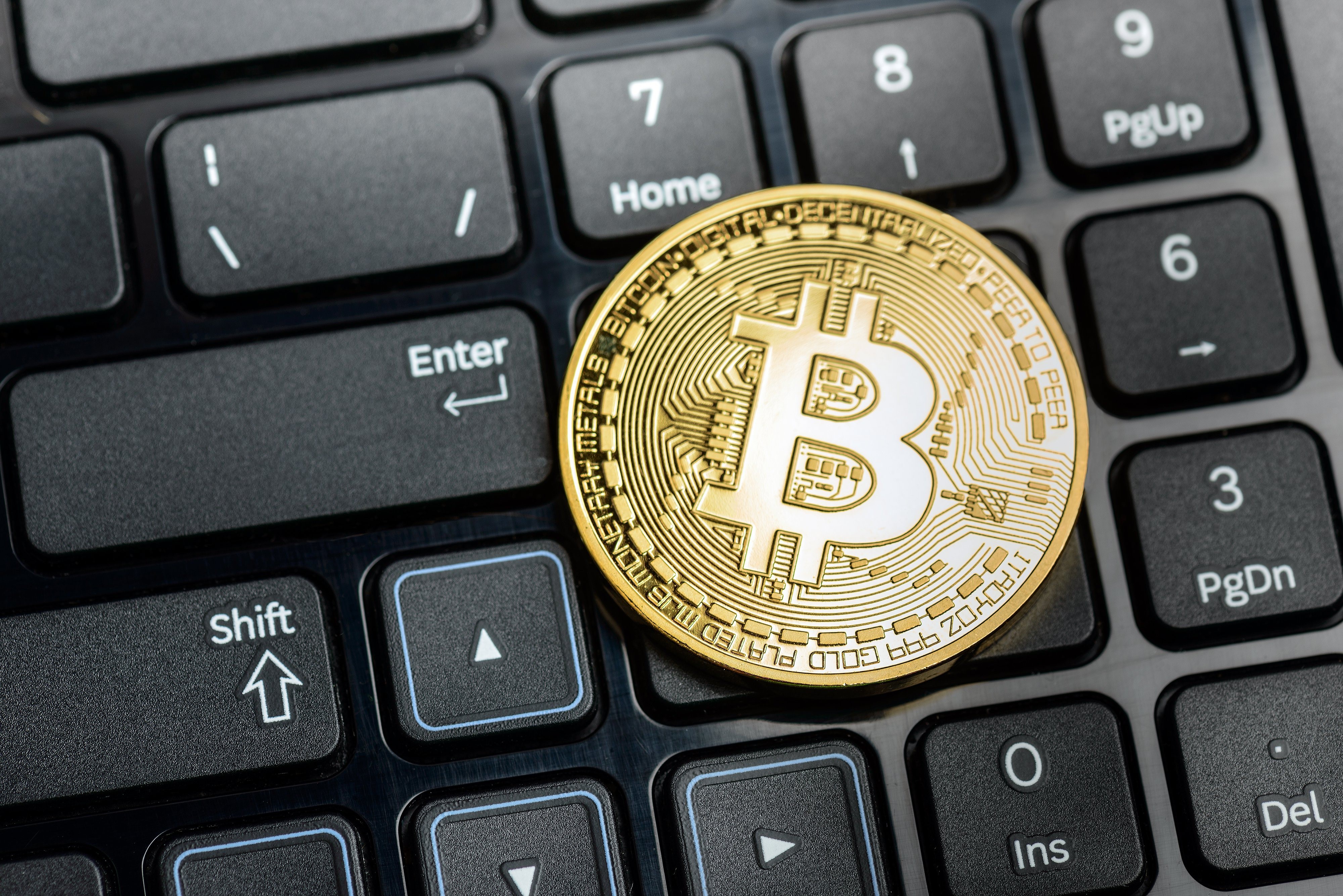 Bitcoin coin on a computer keyboard HD Wallpaper