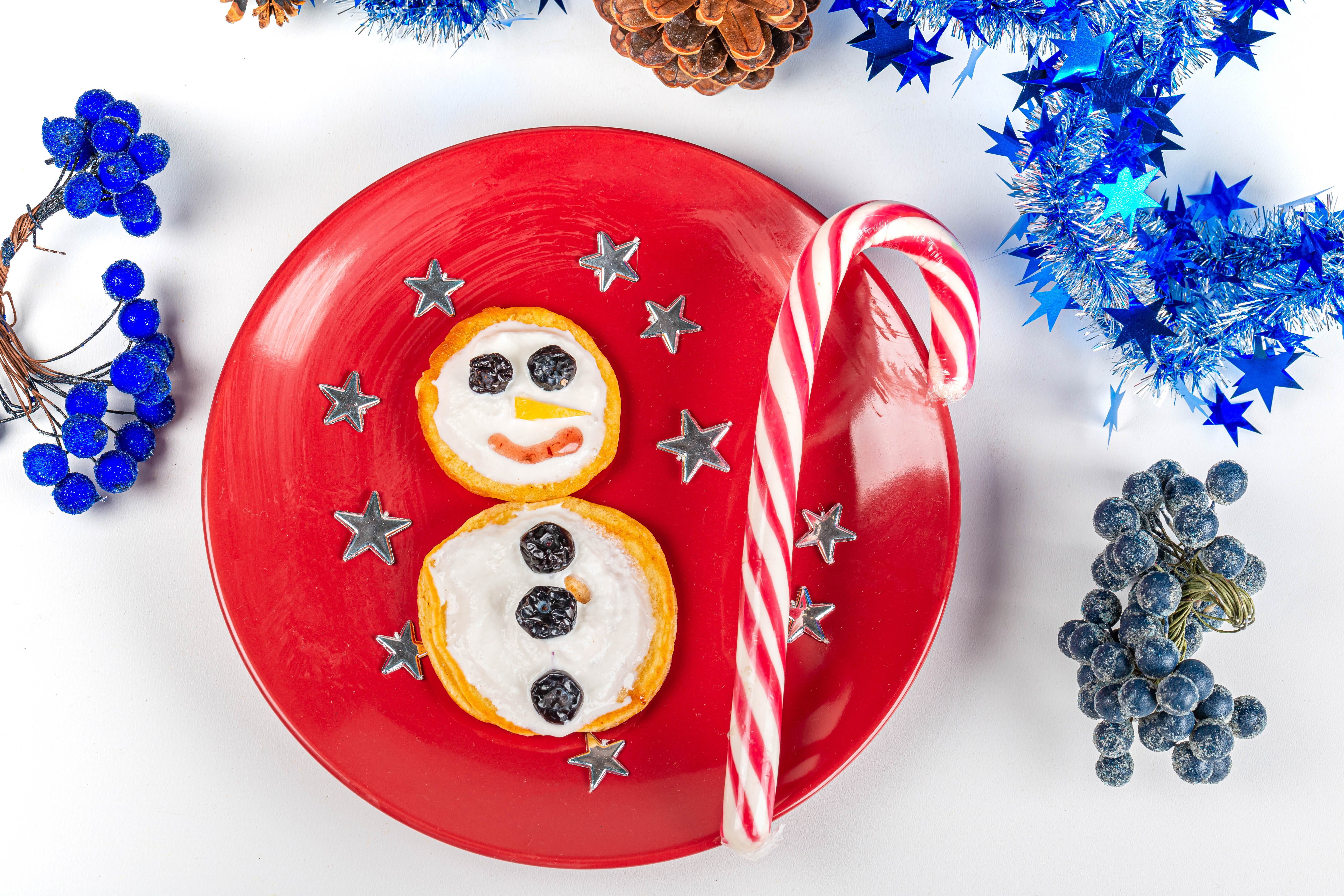 Christmas snowman pancake with candy cane on red plate HD Wallpaper