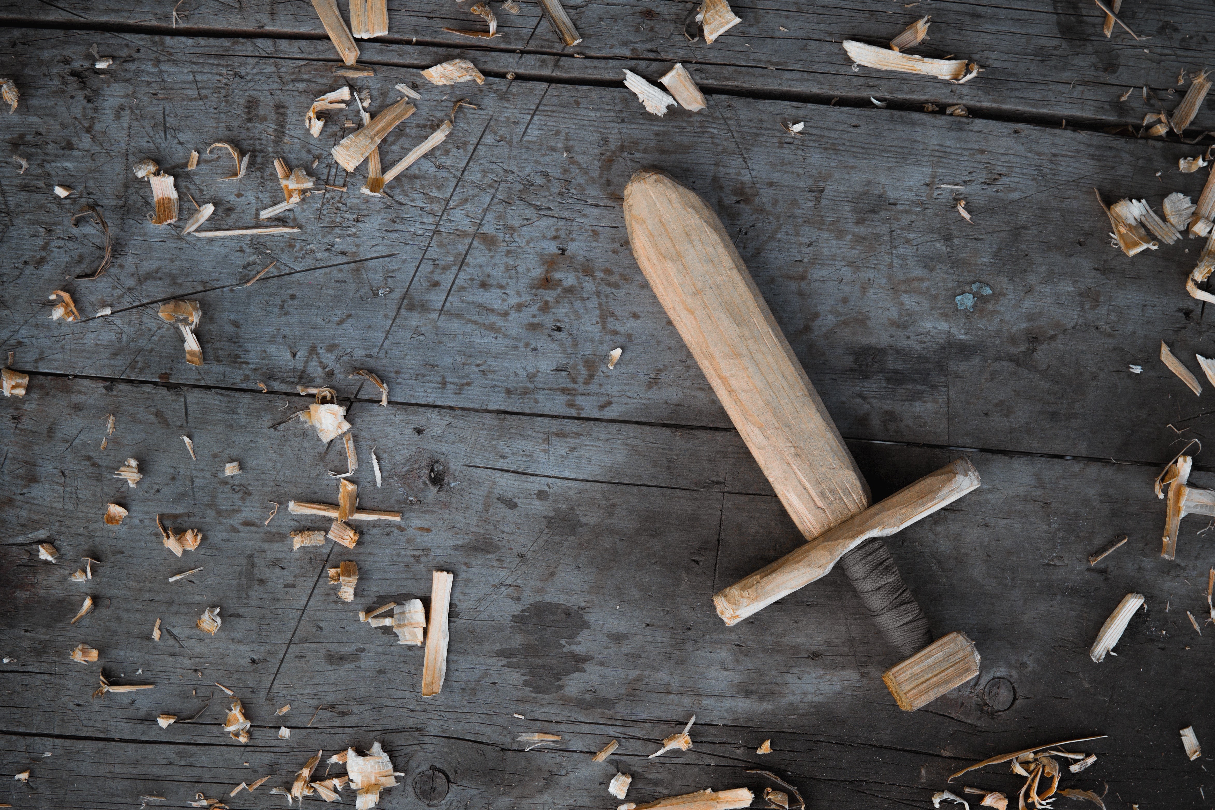 Wooden sword on wood planks with wood shavings HD Wallpaper