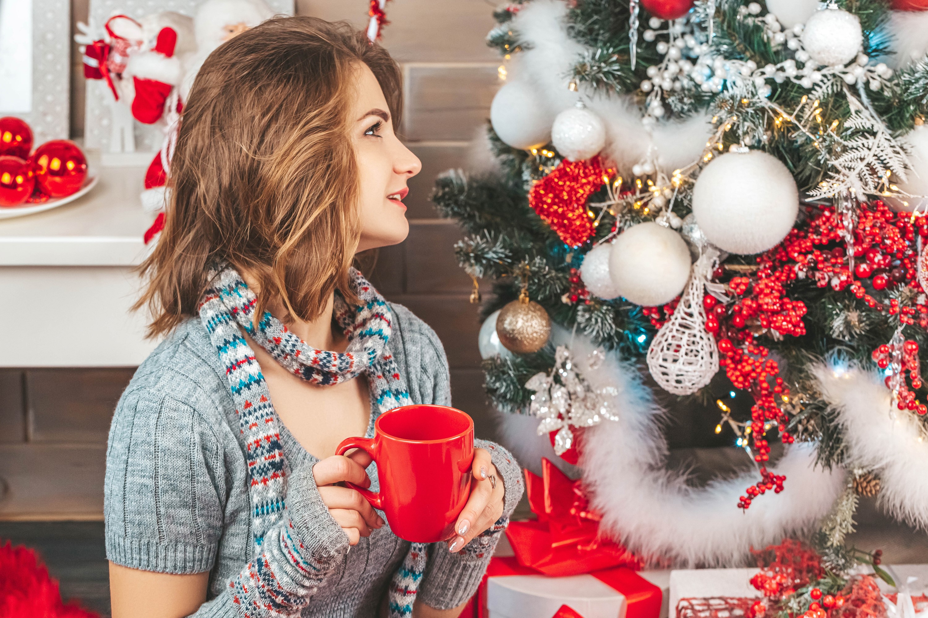 Woman holding a mug by a Christmas tree HD Wallpaper