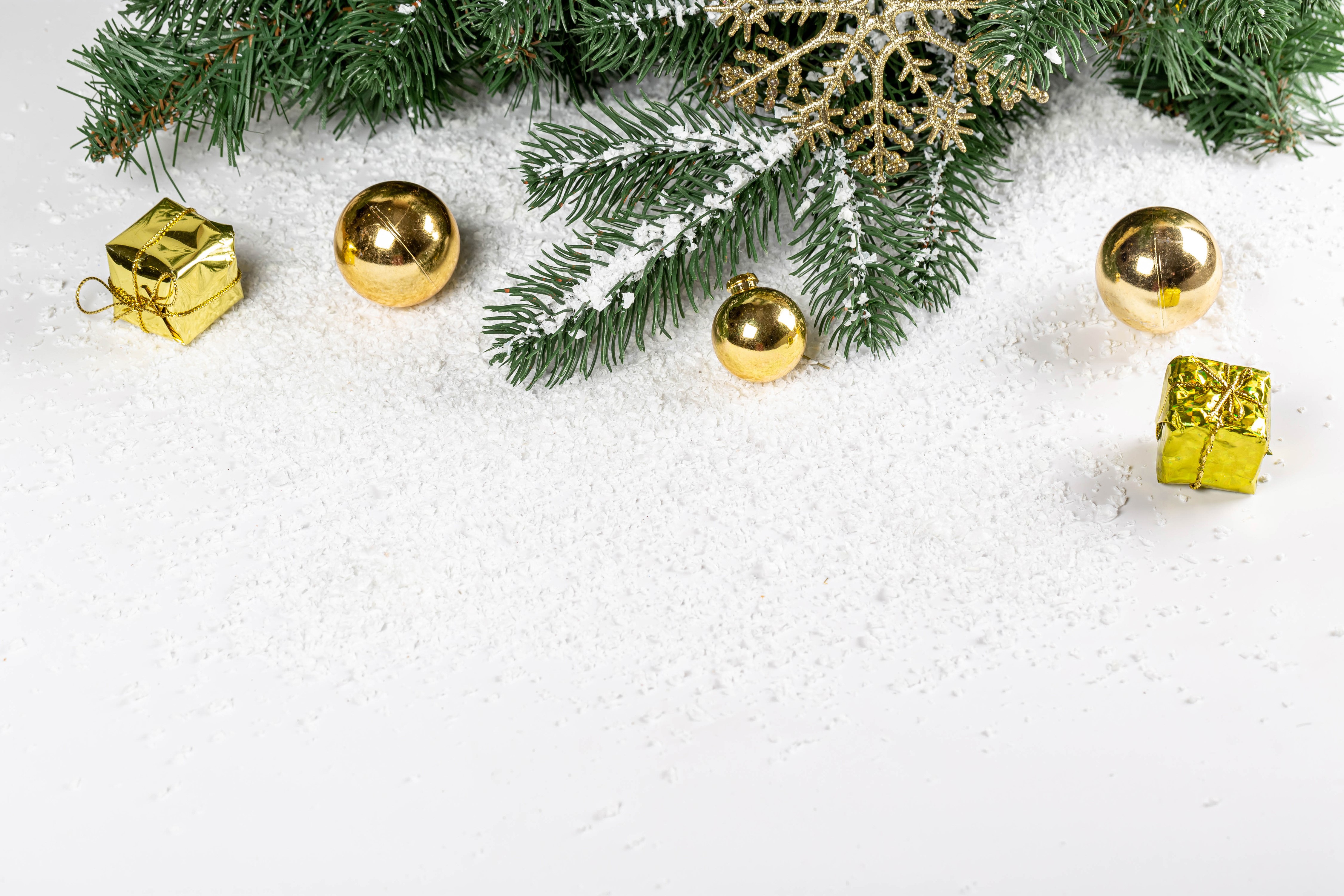 Christmas branches with golden ornaments and gifts on snow HD Wallpaper
