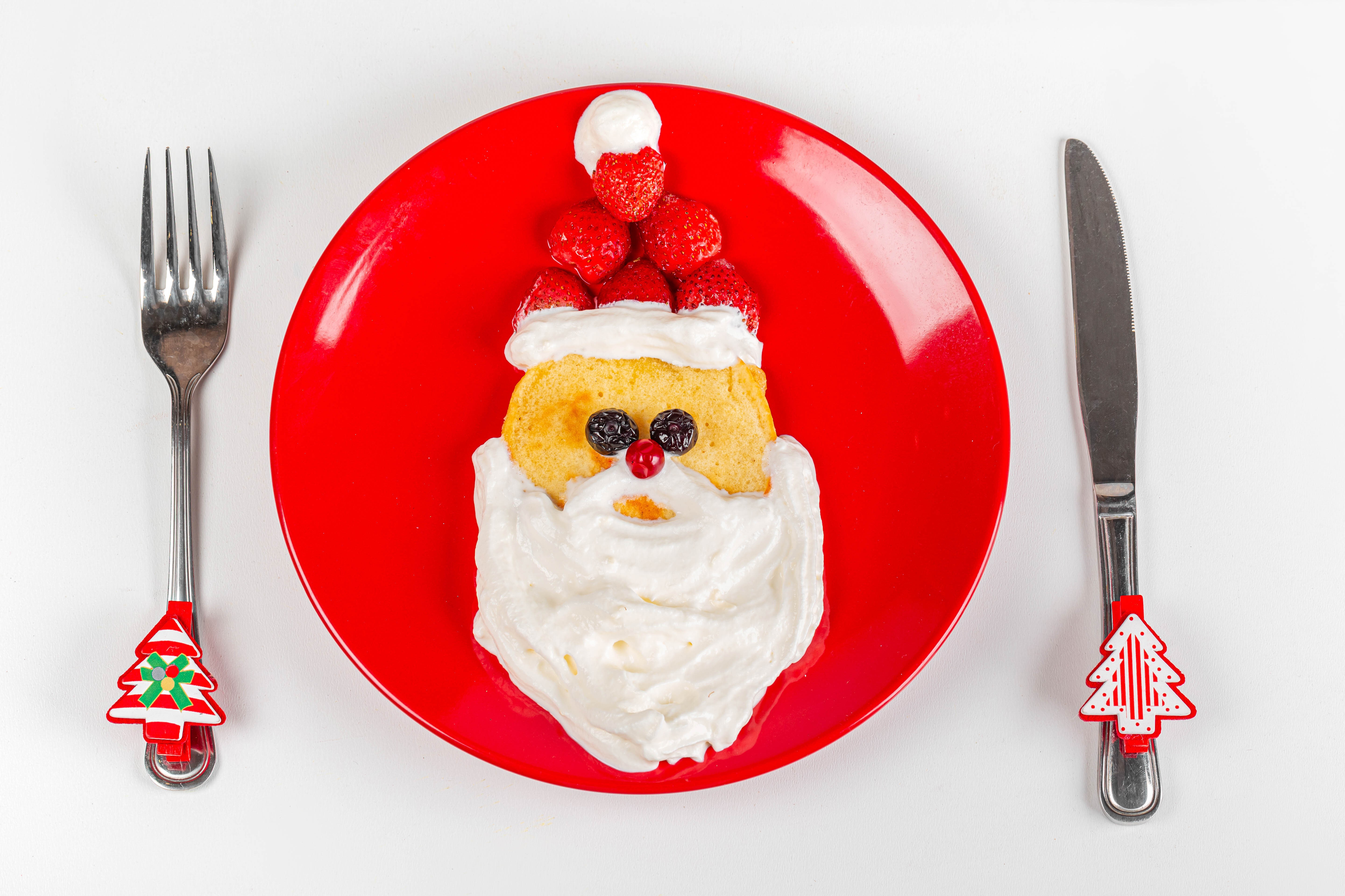 Santa Claus pancake with strawberries and whipped cream on a red plate HD Wallpaper