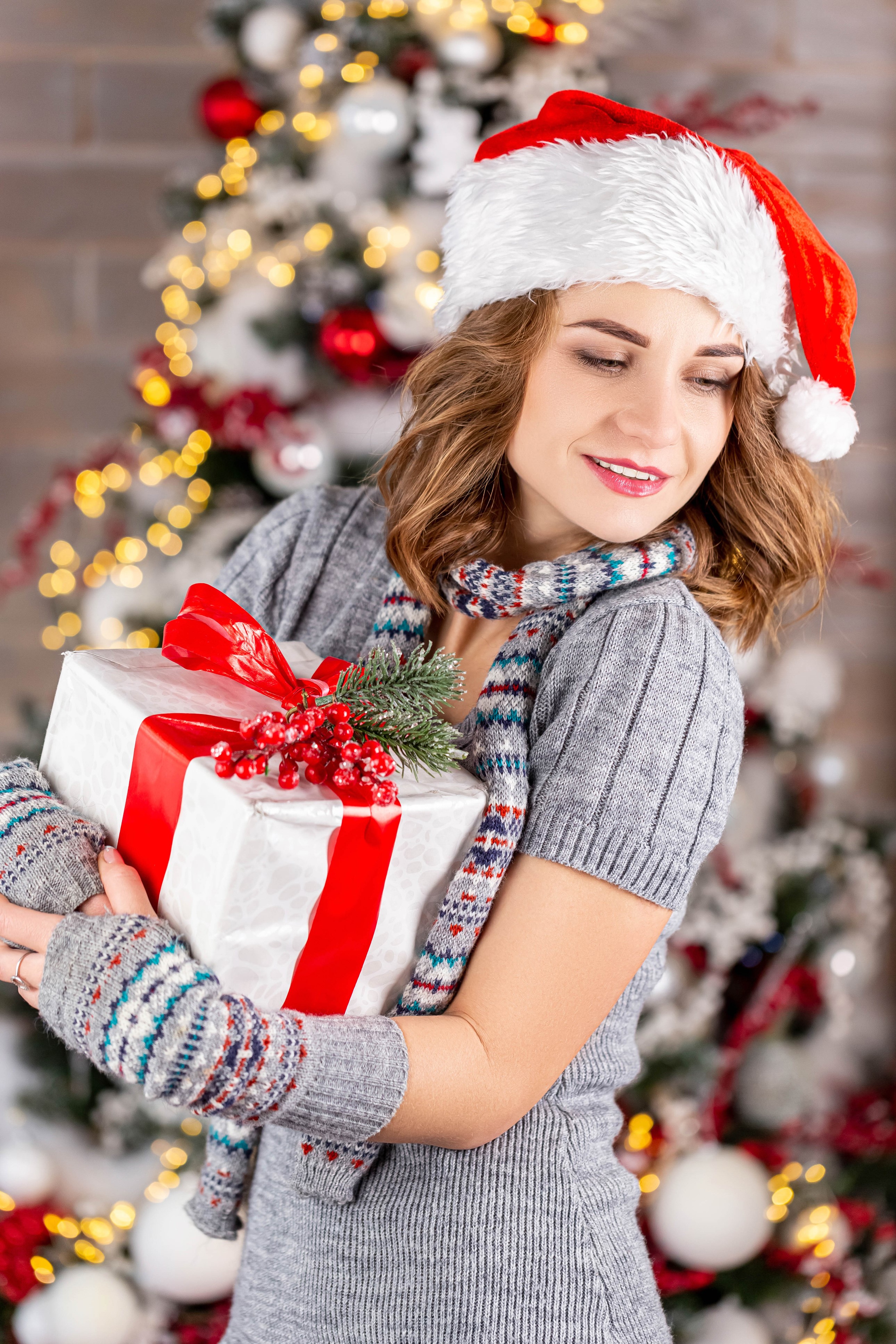 Woman in Santa hat holding a Christmas gift HD Phone Wallpaper