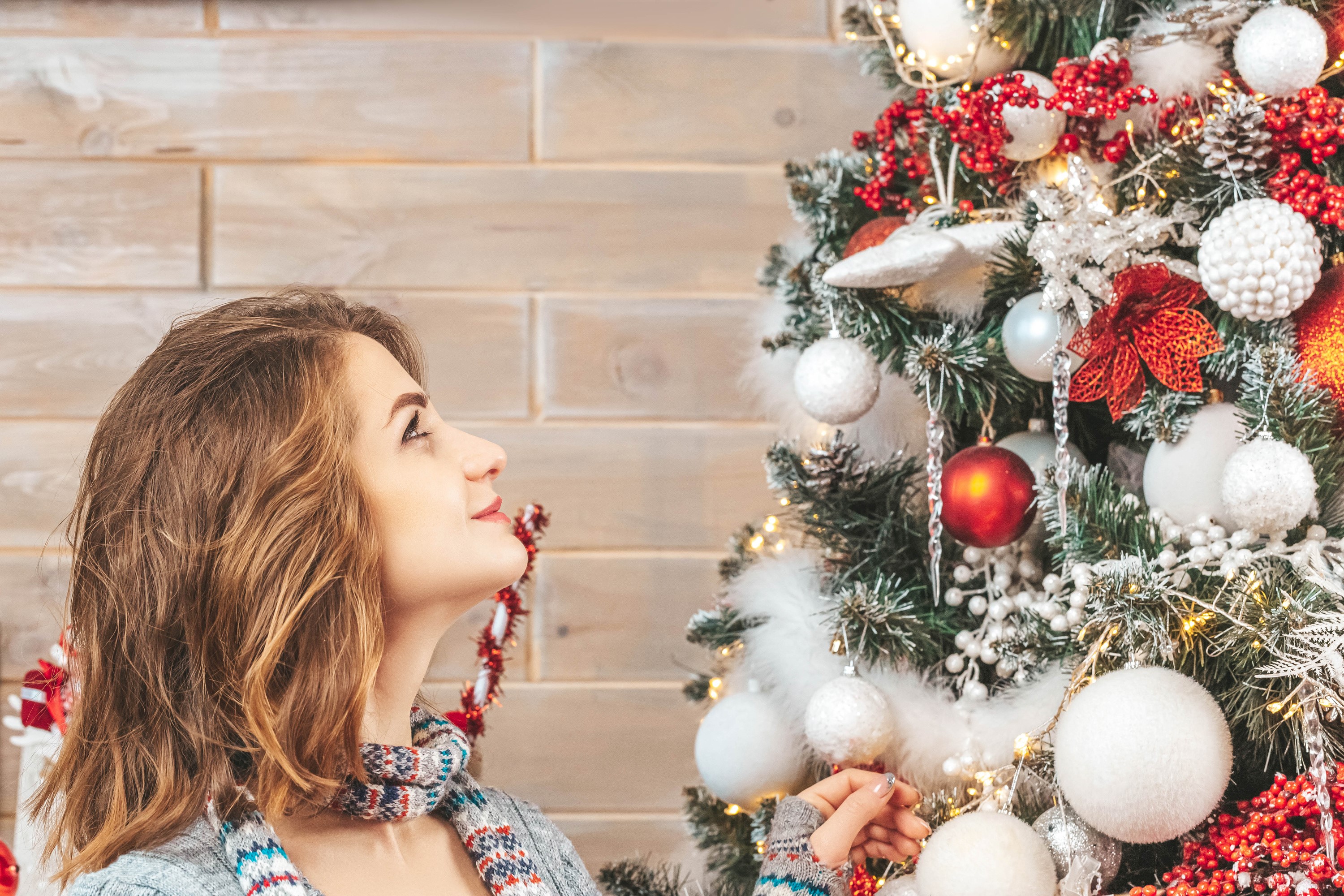 Woman looking at a decorated Christmas tree HD Wallpaper