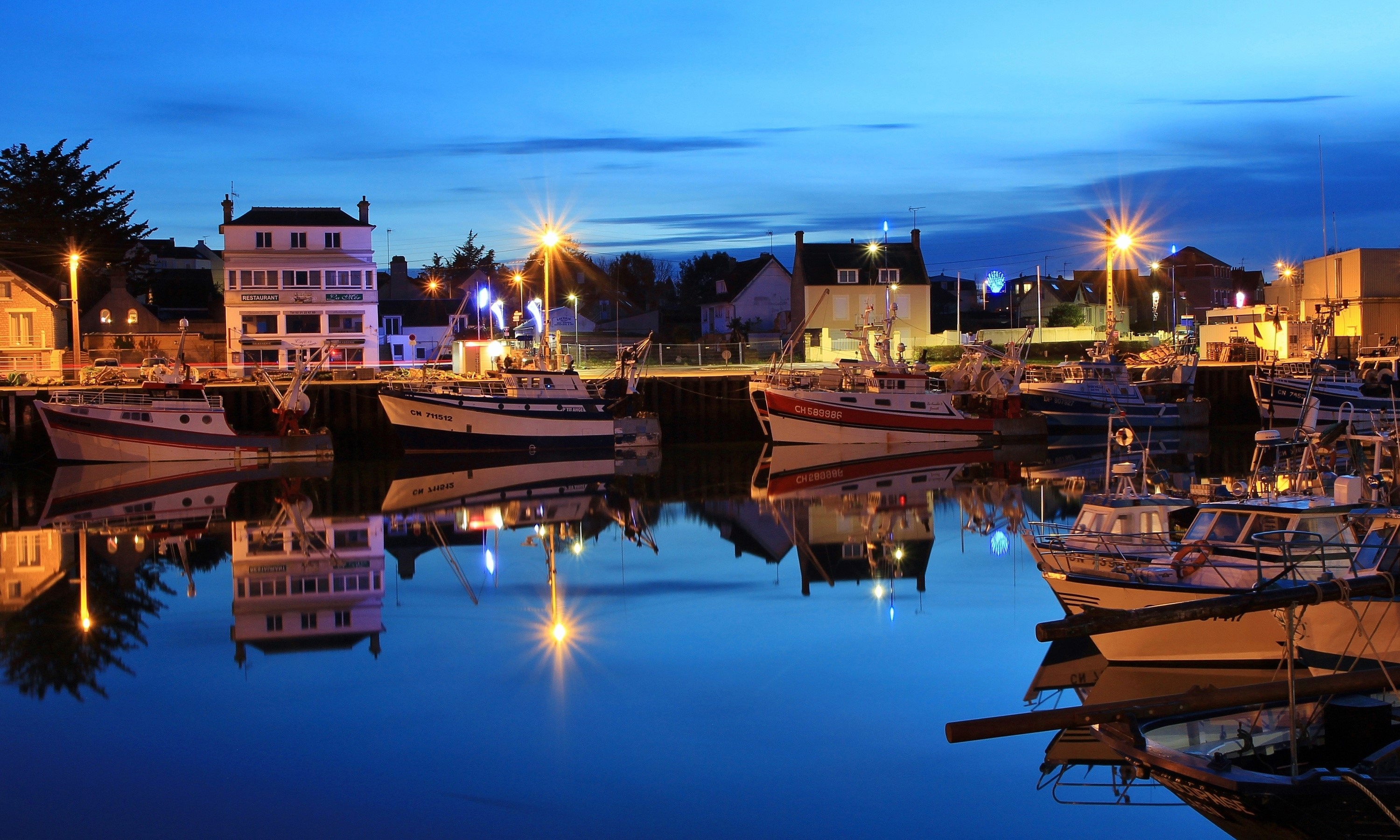 Boats docked in a harbor at Grandcamp-Maisy, Calvados, France at dusk HD Wallpaper