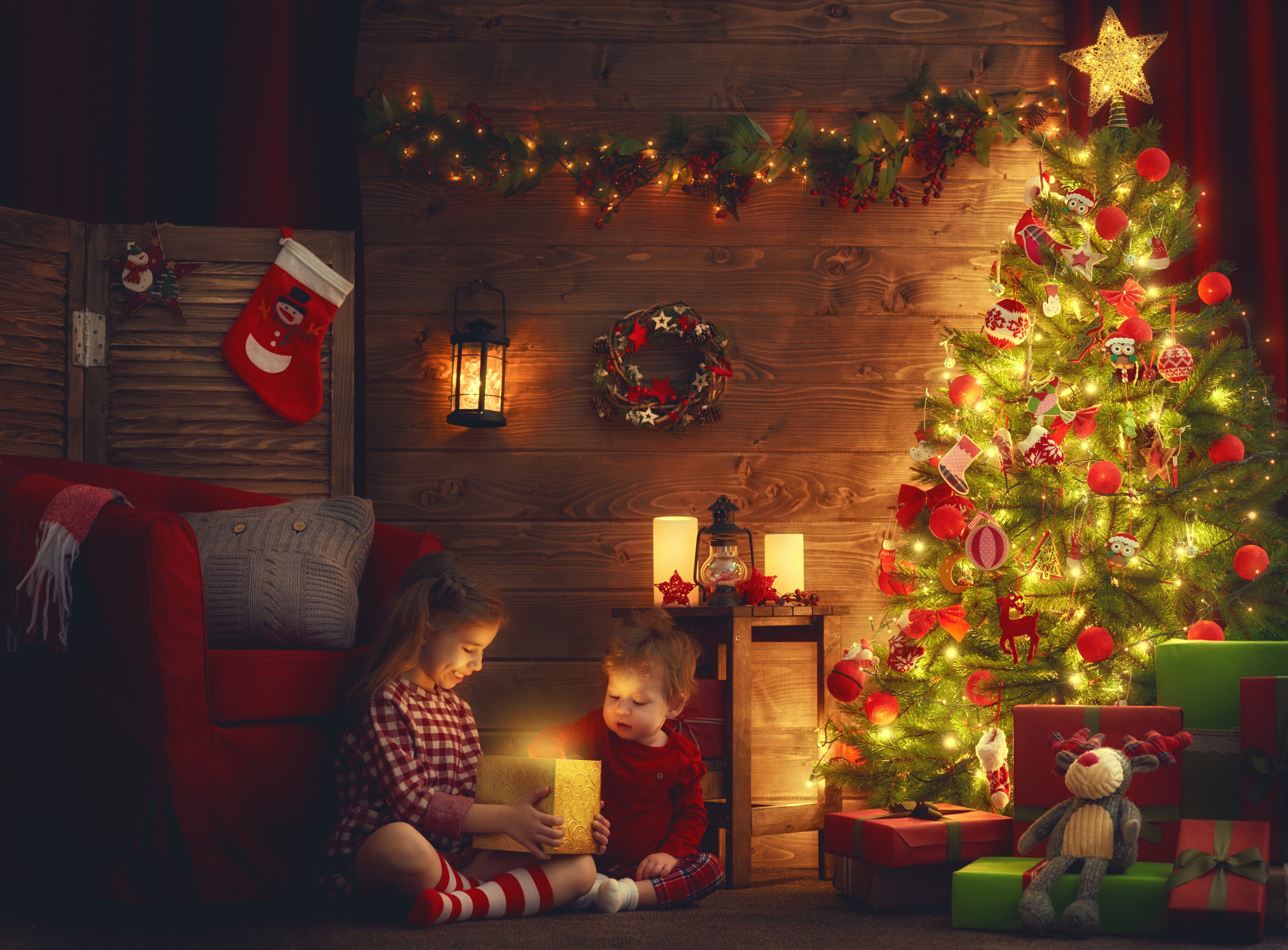 Children opening Christmas gifts by the tree HD Wallpaper