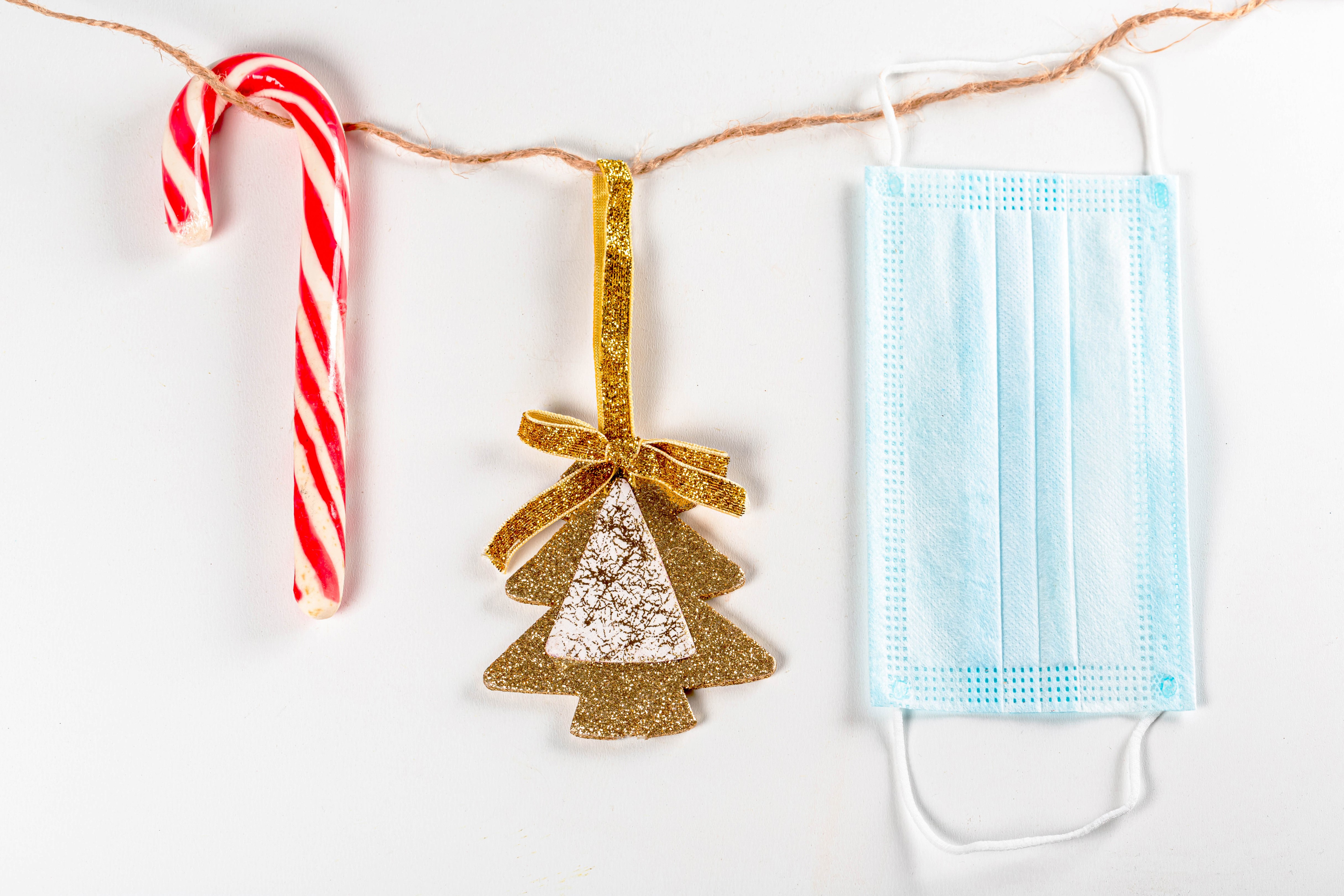 Christmas candy cane, tree ornament, and face mask on string HD Wallpaper