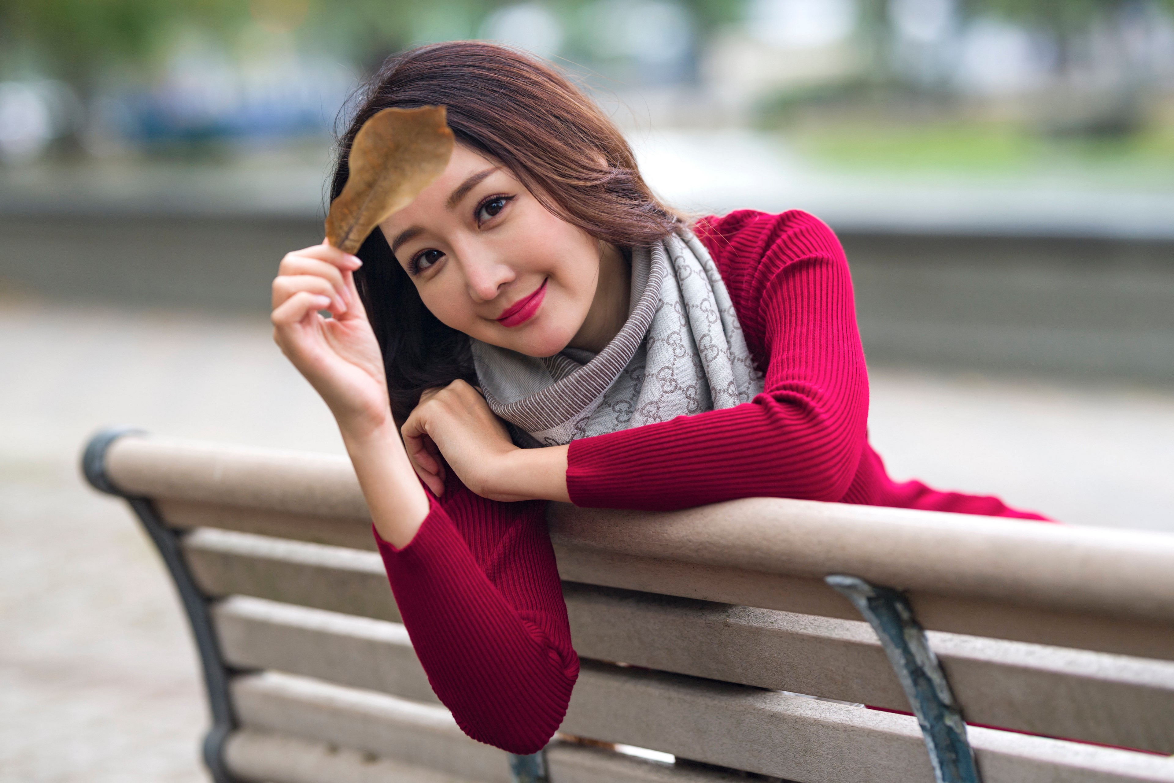 Asian woman with leaf on bench HD Wallpaper