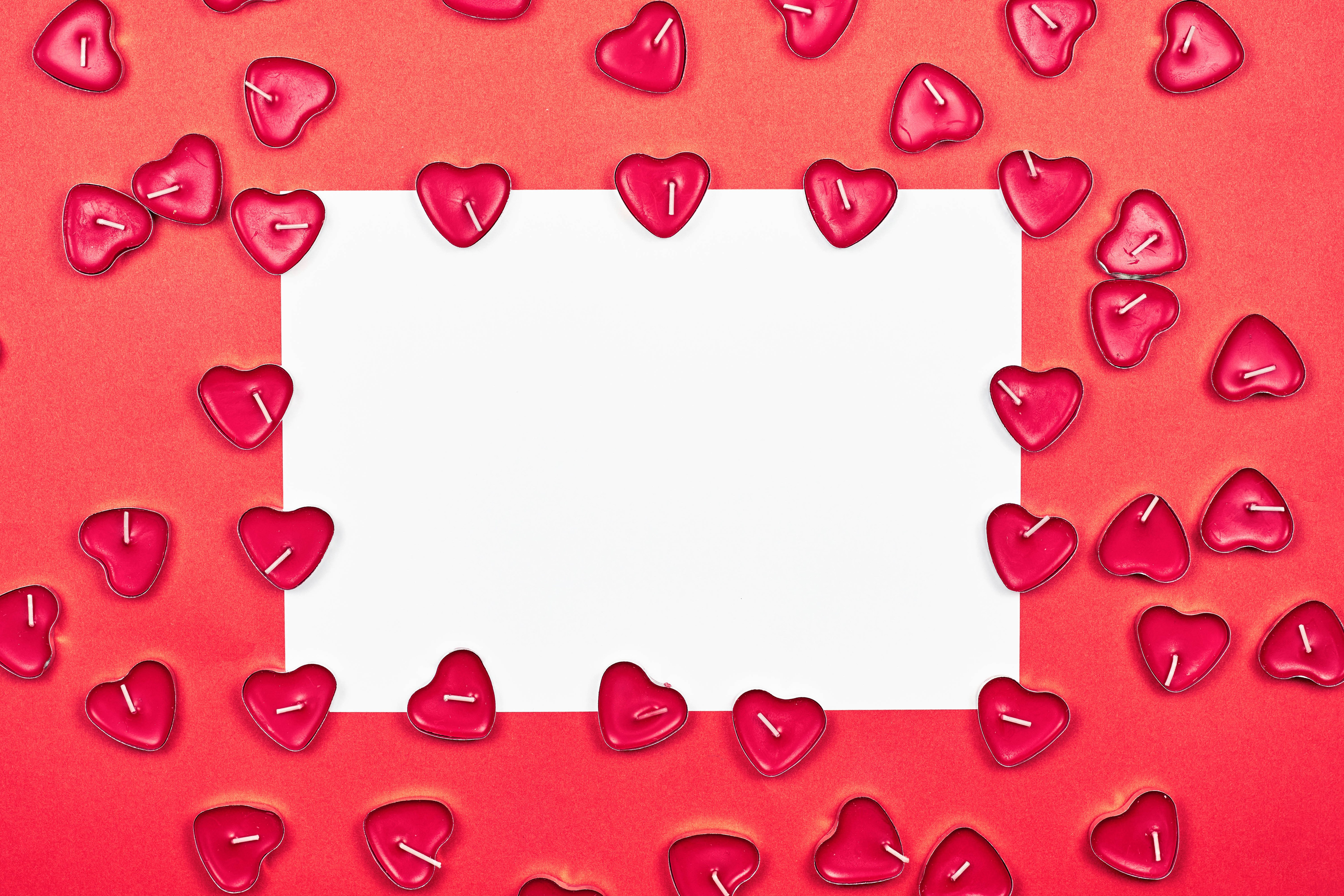 Heart-shaped candles around a blank white sheet of paper HD Wallpaper