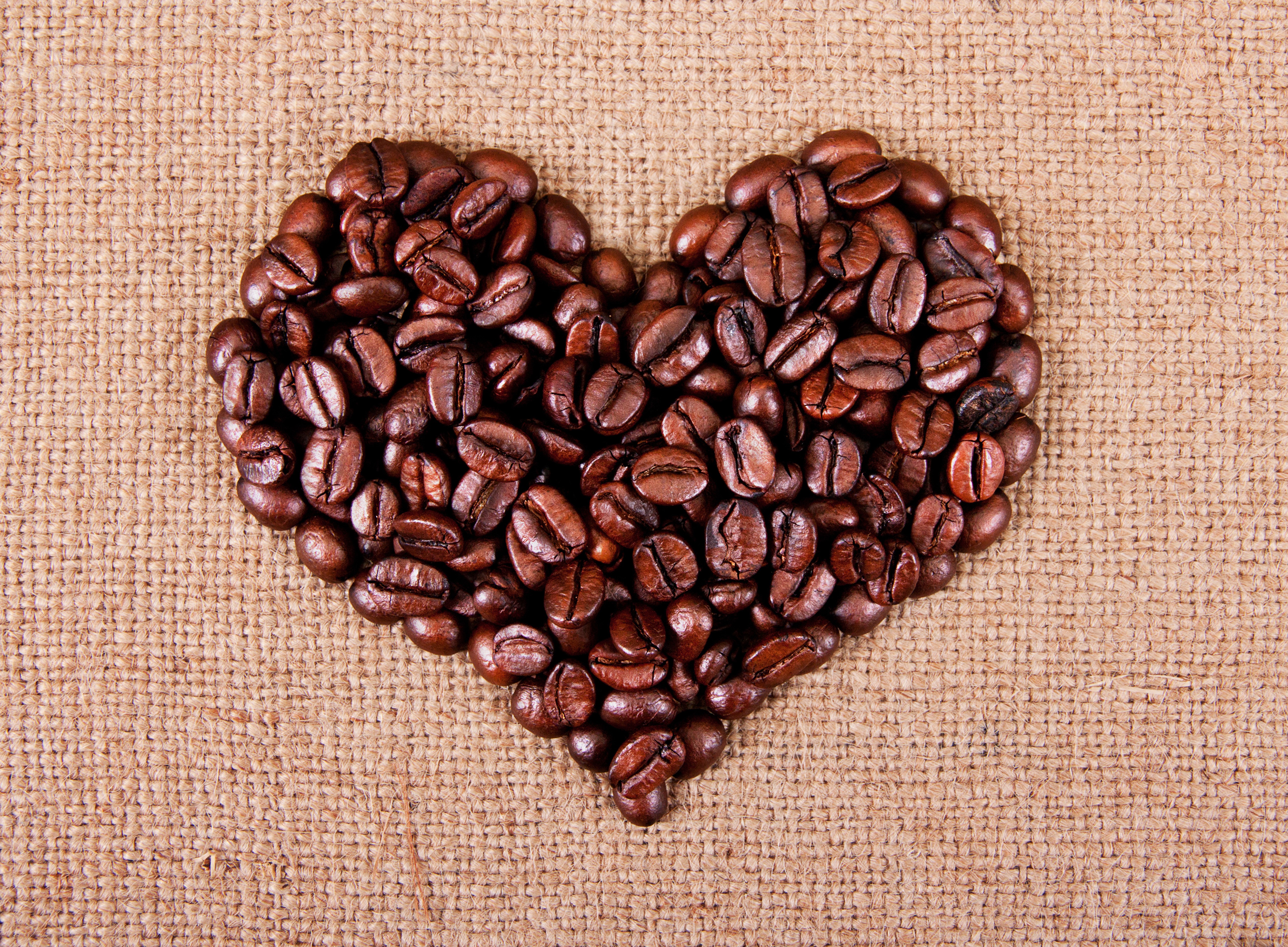 Heart shape made of coffee beans on burlap HD Wallpaper