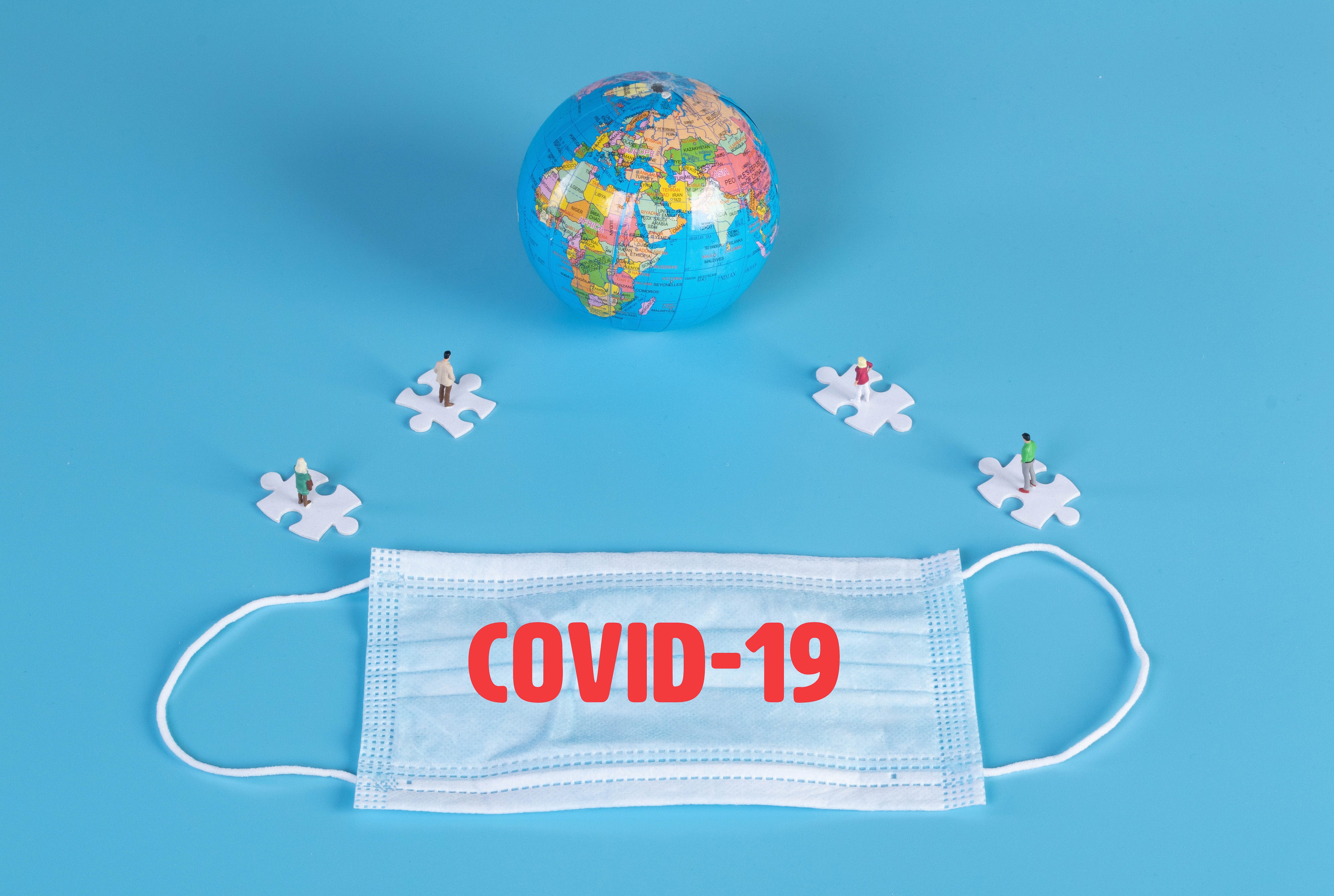 COVID-19 mask and globe with puzzle pieces HD Wallpaper
