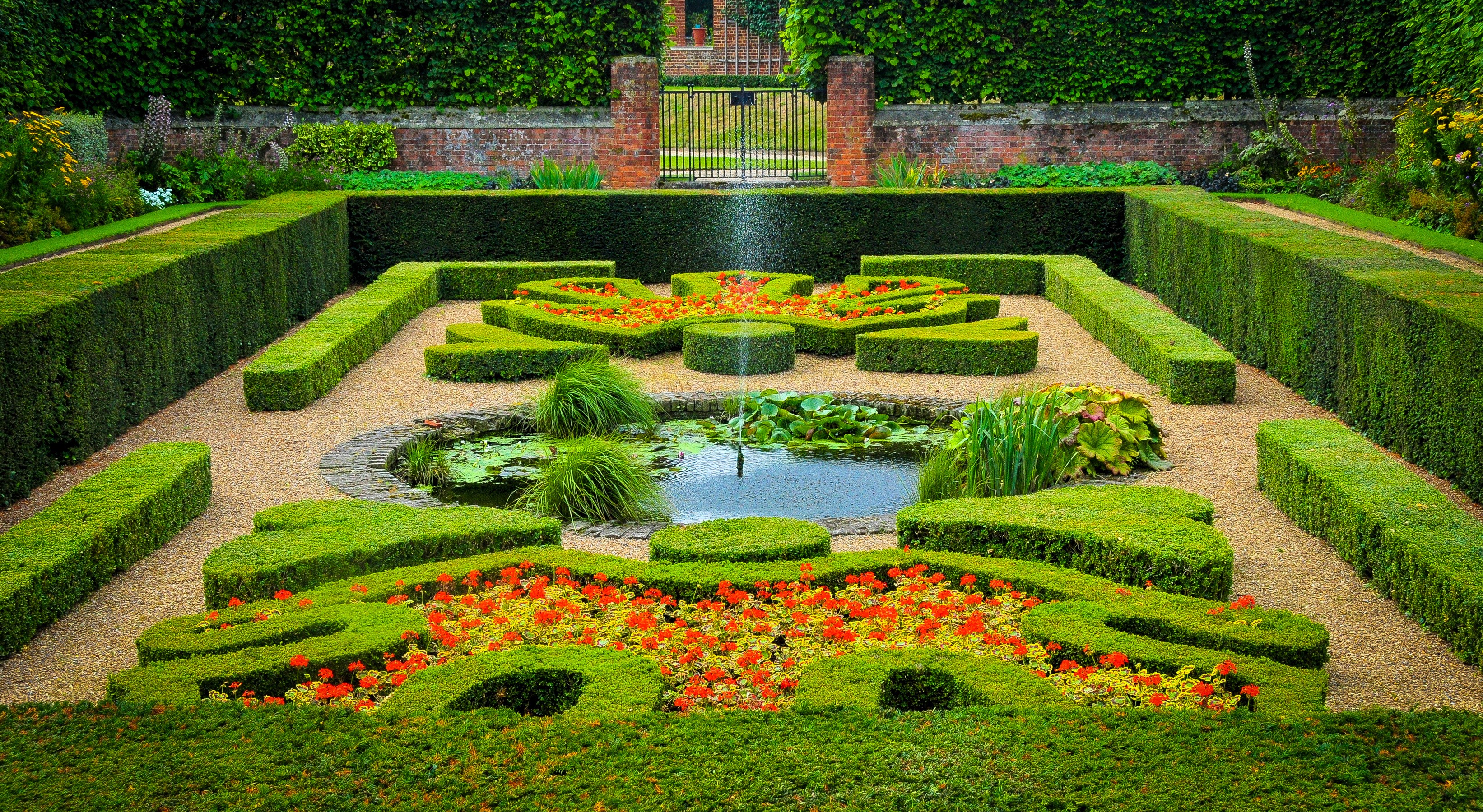 Formal garden with geometric hedges and flowers HD Wallpaper
