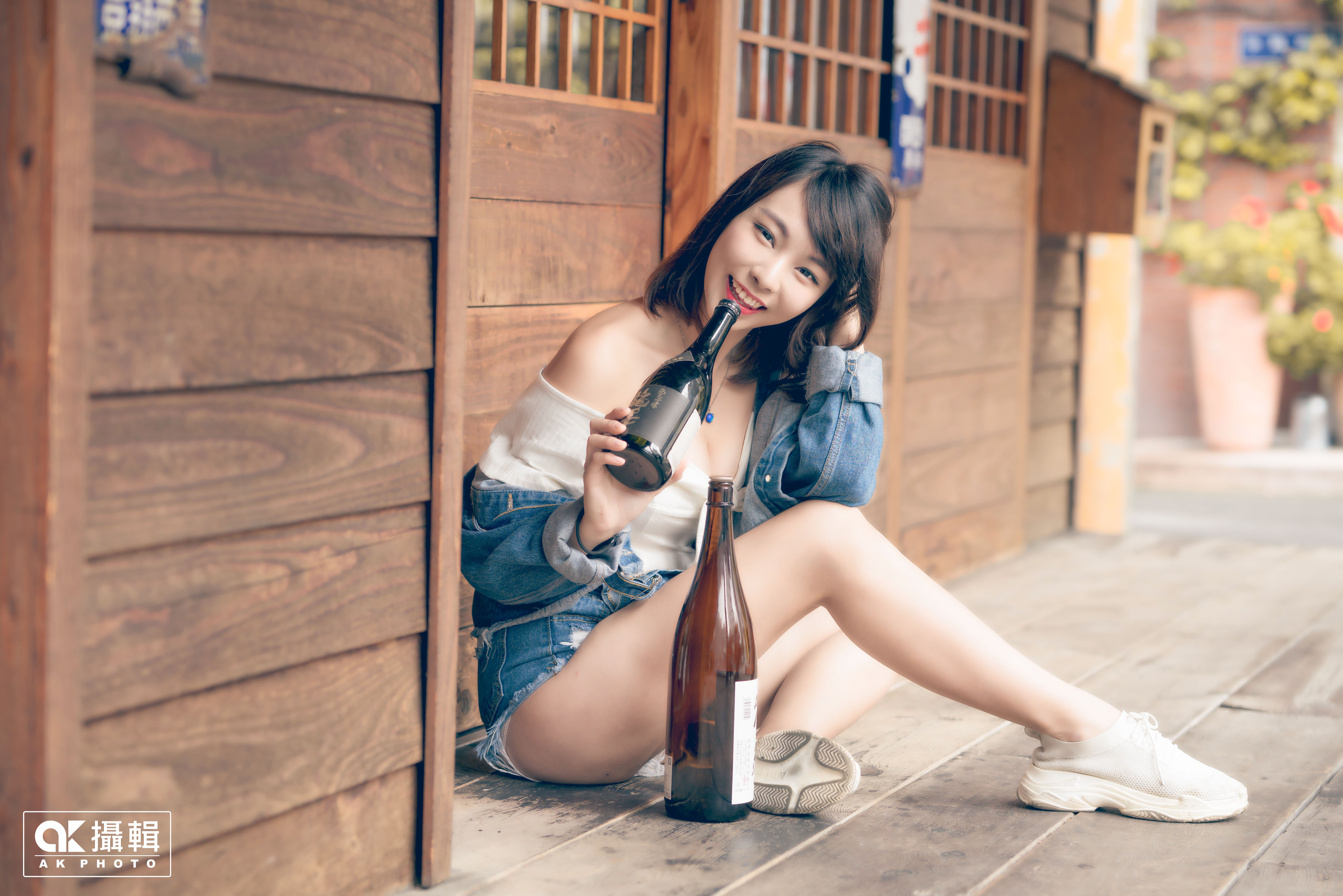 Asian girl with bottles sitting outdoors HD Wallpaper