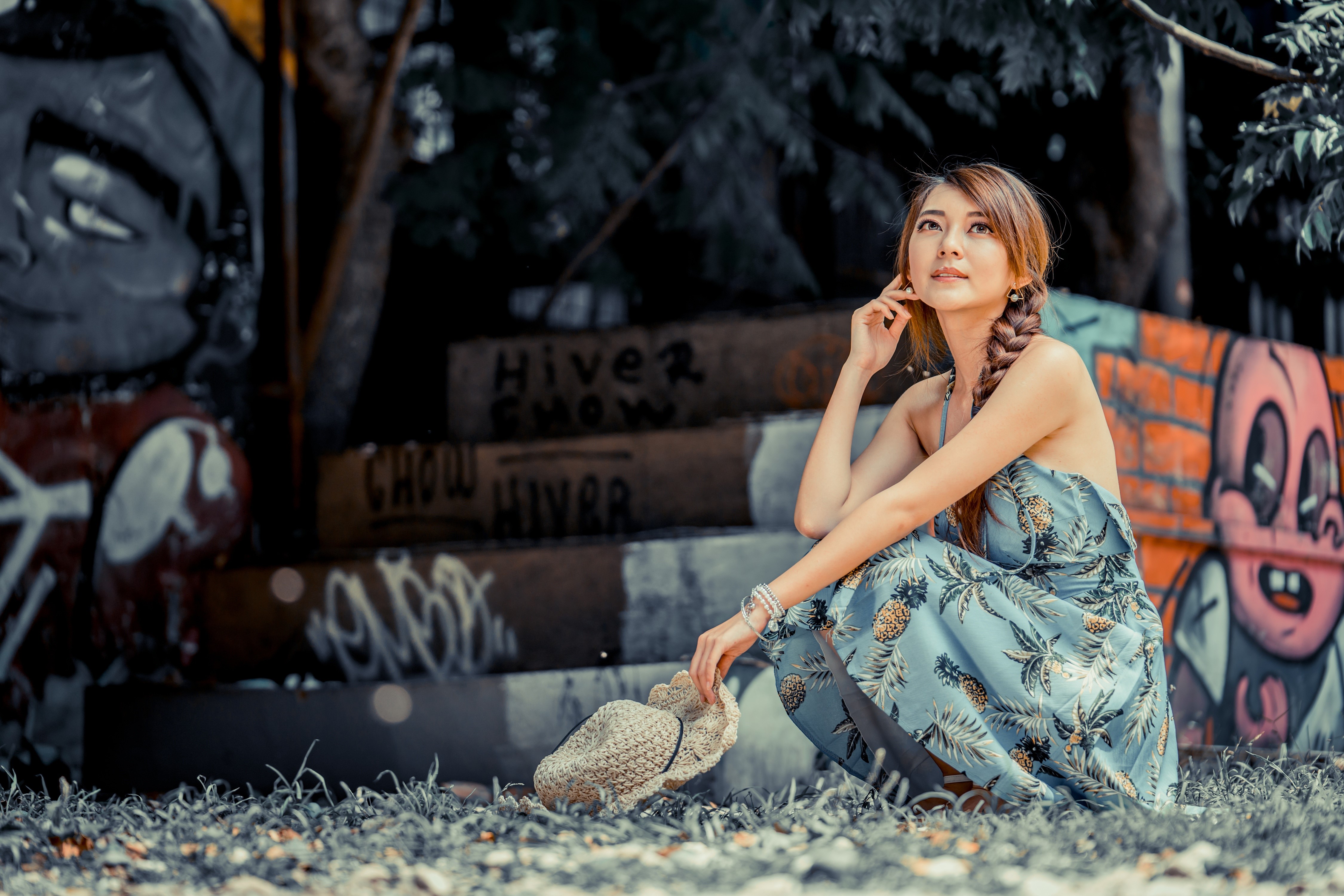 Asian woman in dress sitting near graffiti HD Wallpaper