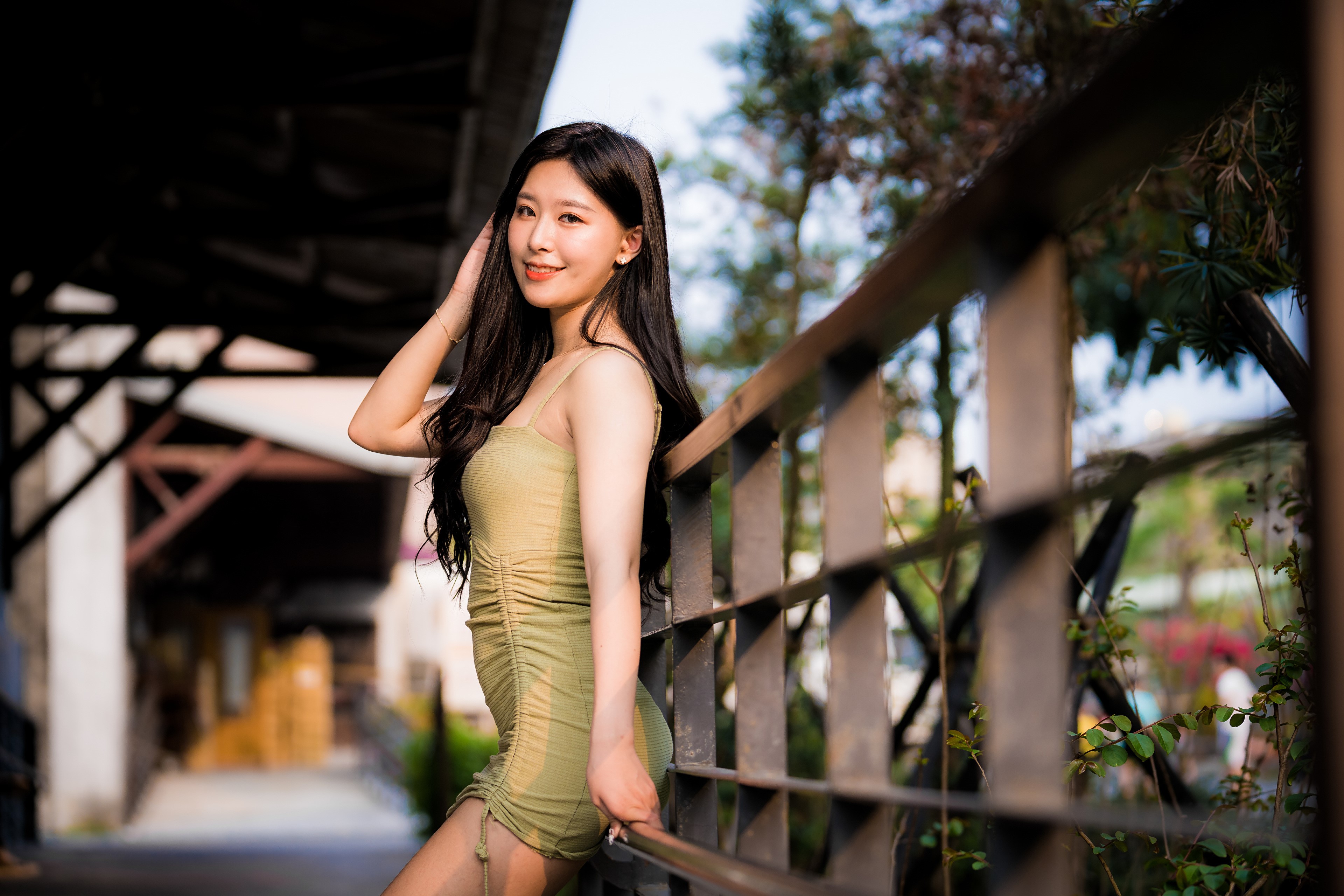Asian woman in a green dress posing by a railing HD Wallpaper