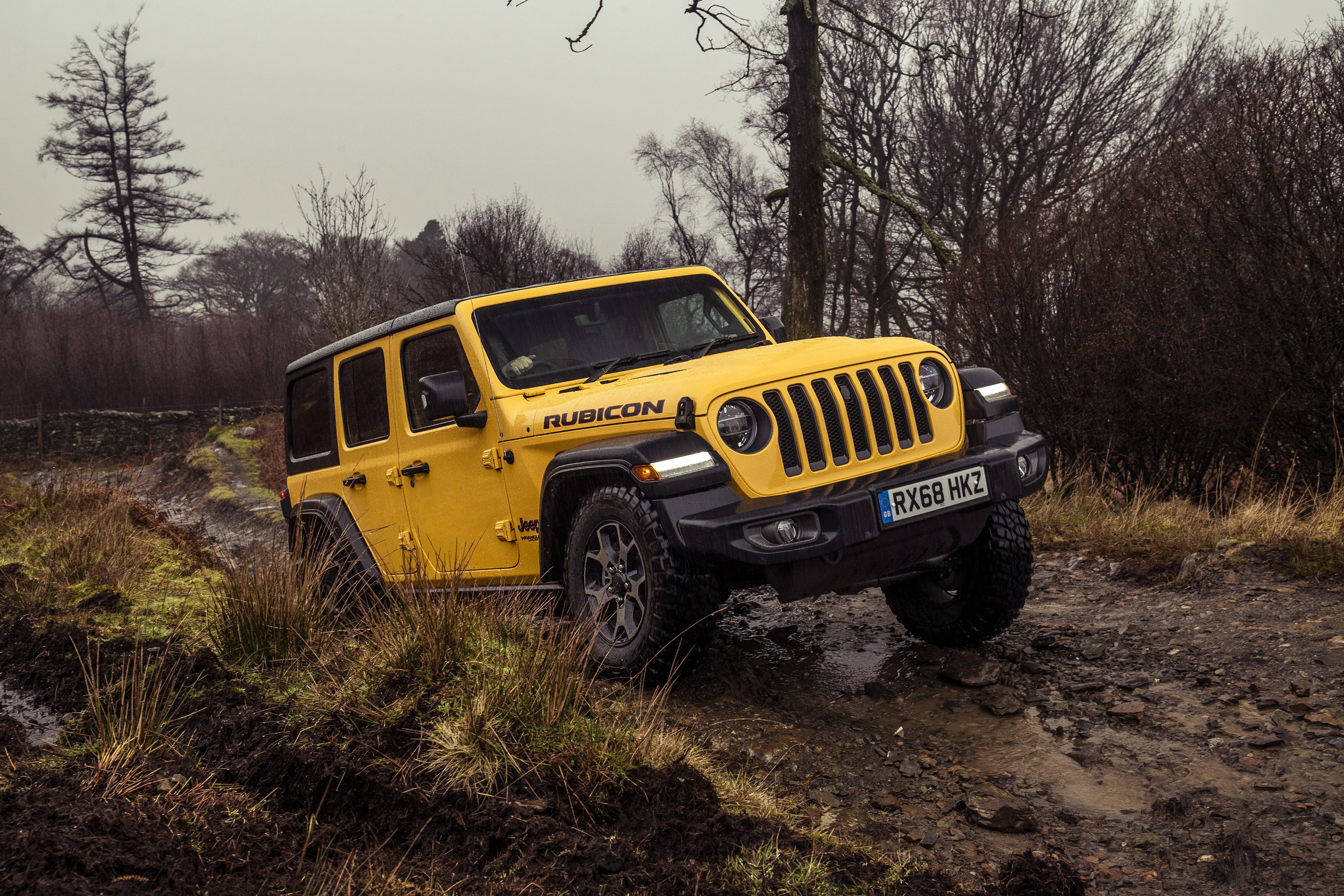 Yellow Jeep Wrangler Rubicon driving on a muddy trail HD Wallpaper