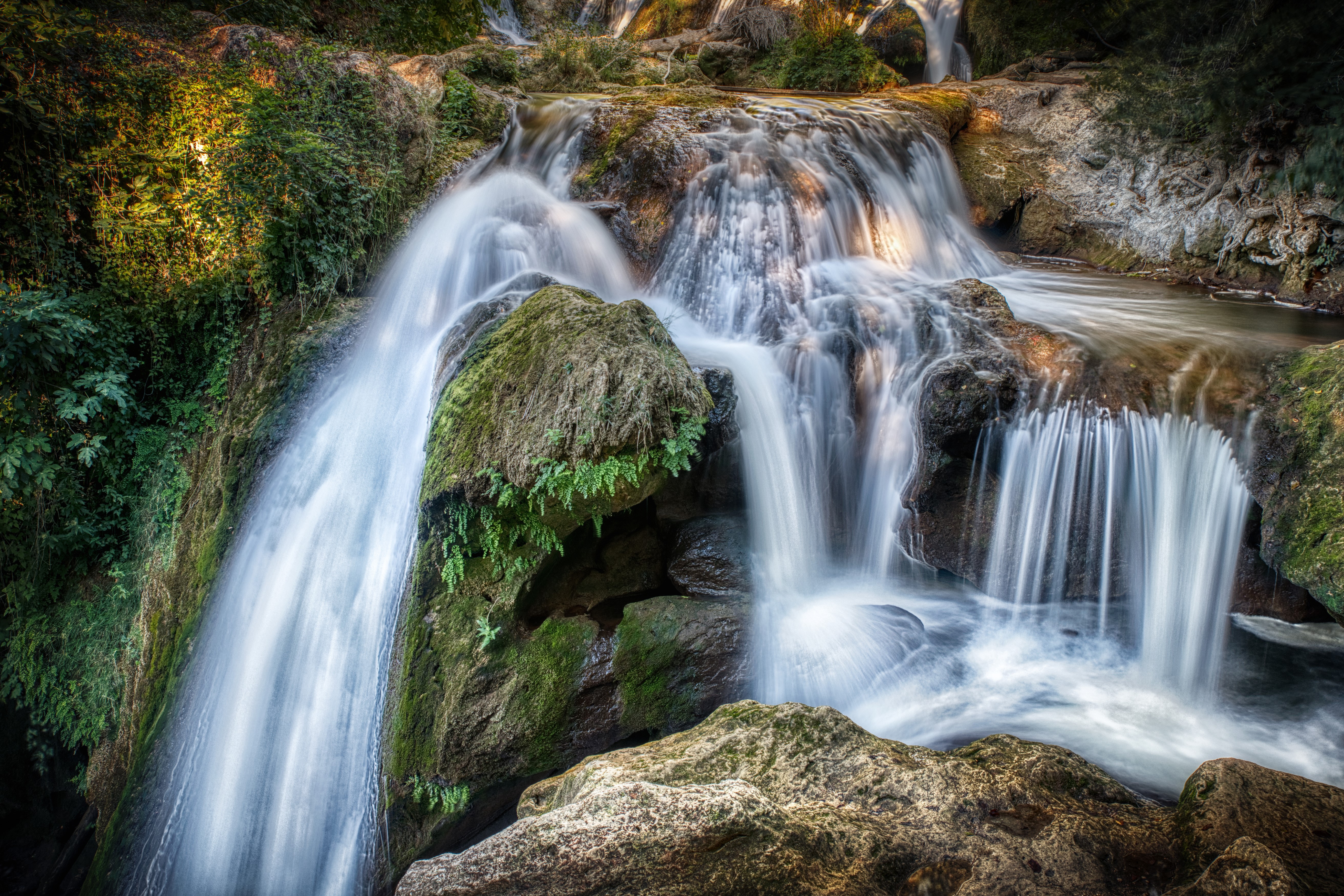 Waterfalls cascading over mossy rocks in France HD Wallpaper
