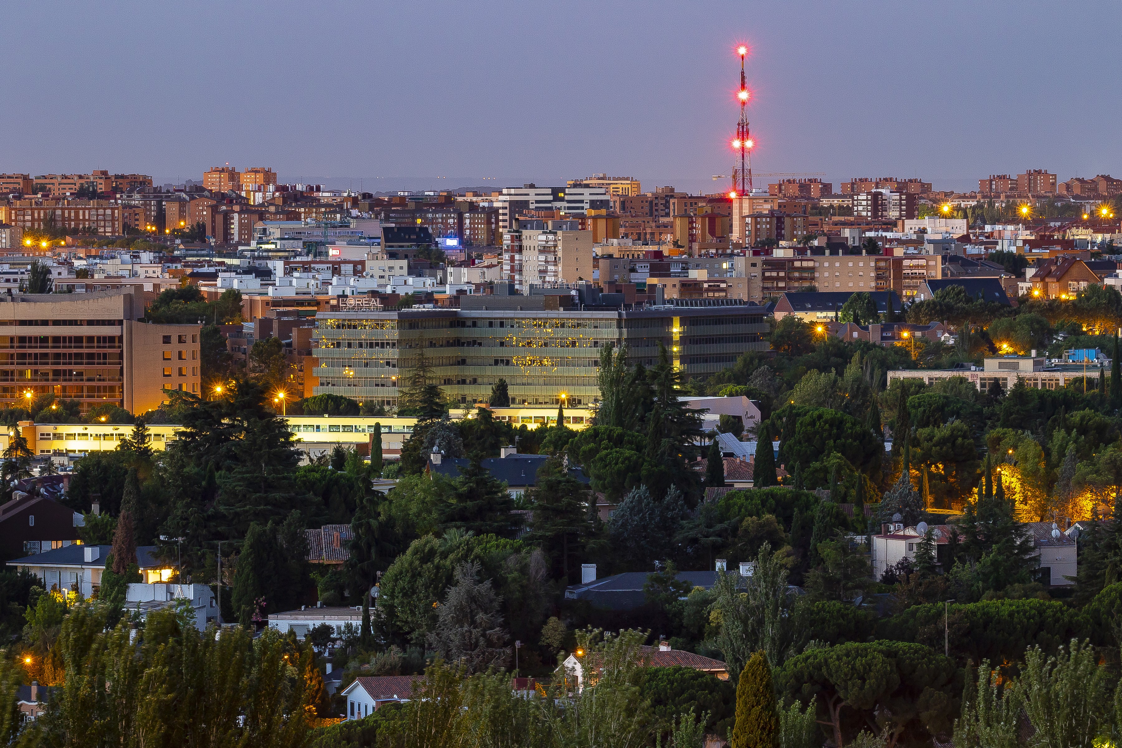 Madrid skyline with buildings and trees at dusk HD Wallpaper
