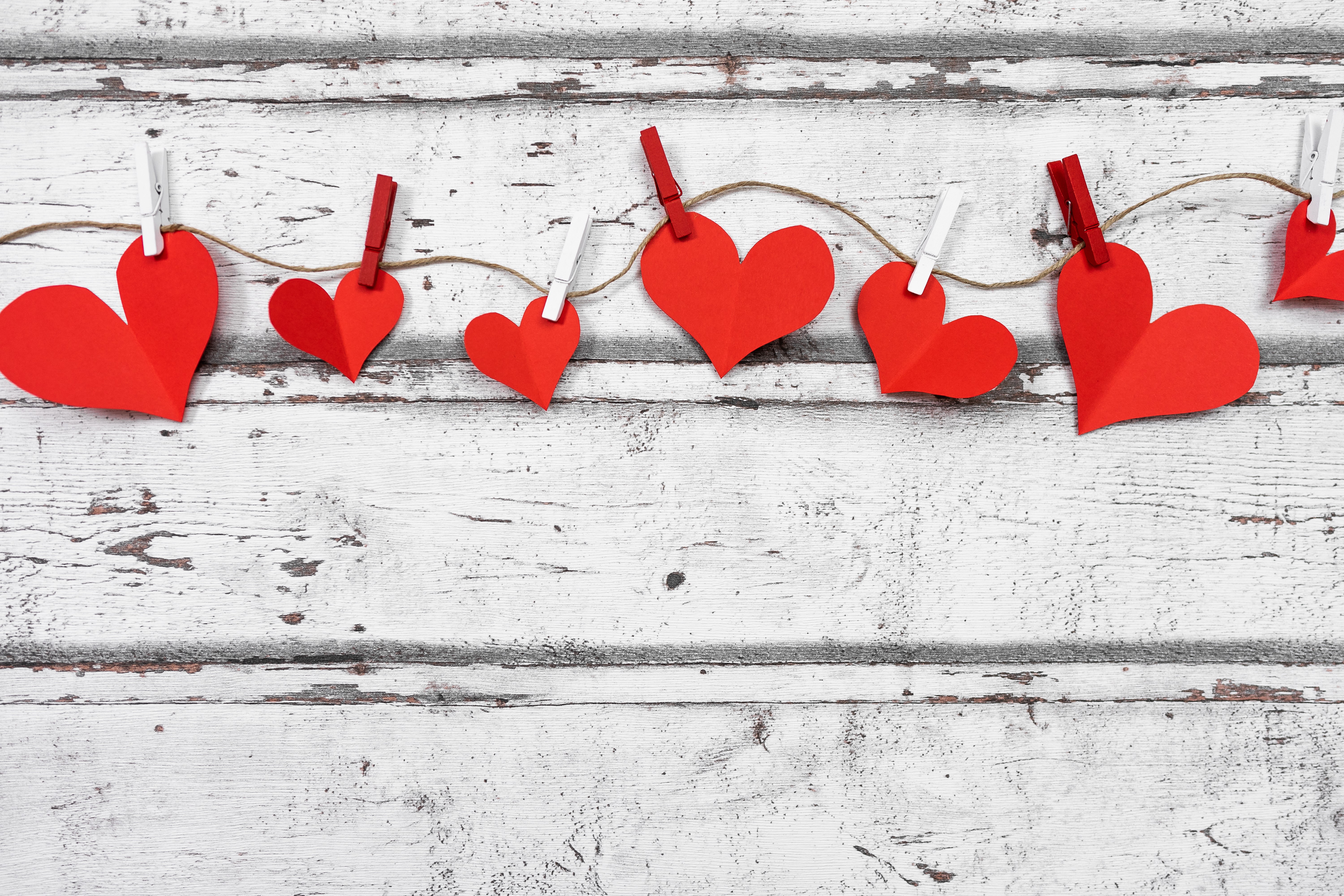 Red paper hearts on a clothesline against wood planks HD Wallpaper