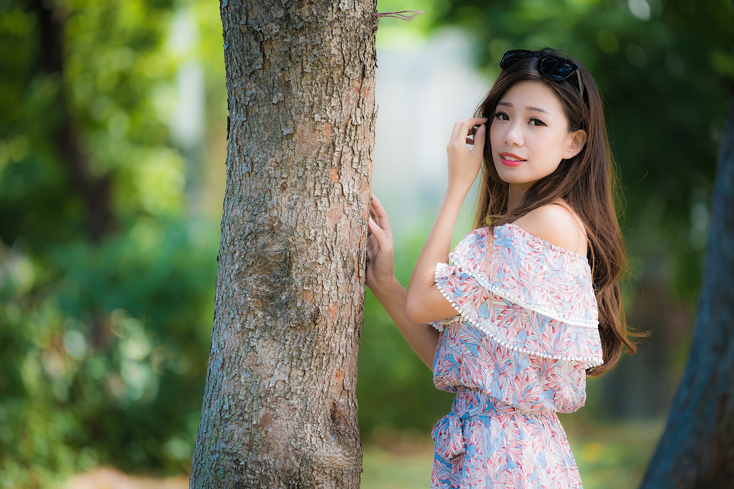 Asian woman with brown hair posing by a tree HD Wallpaper