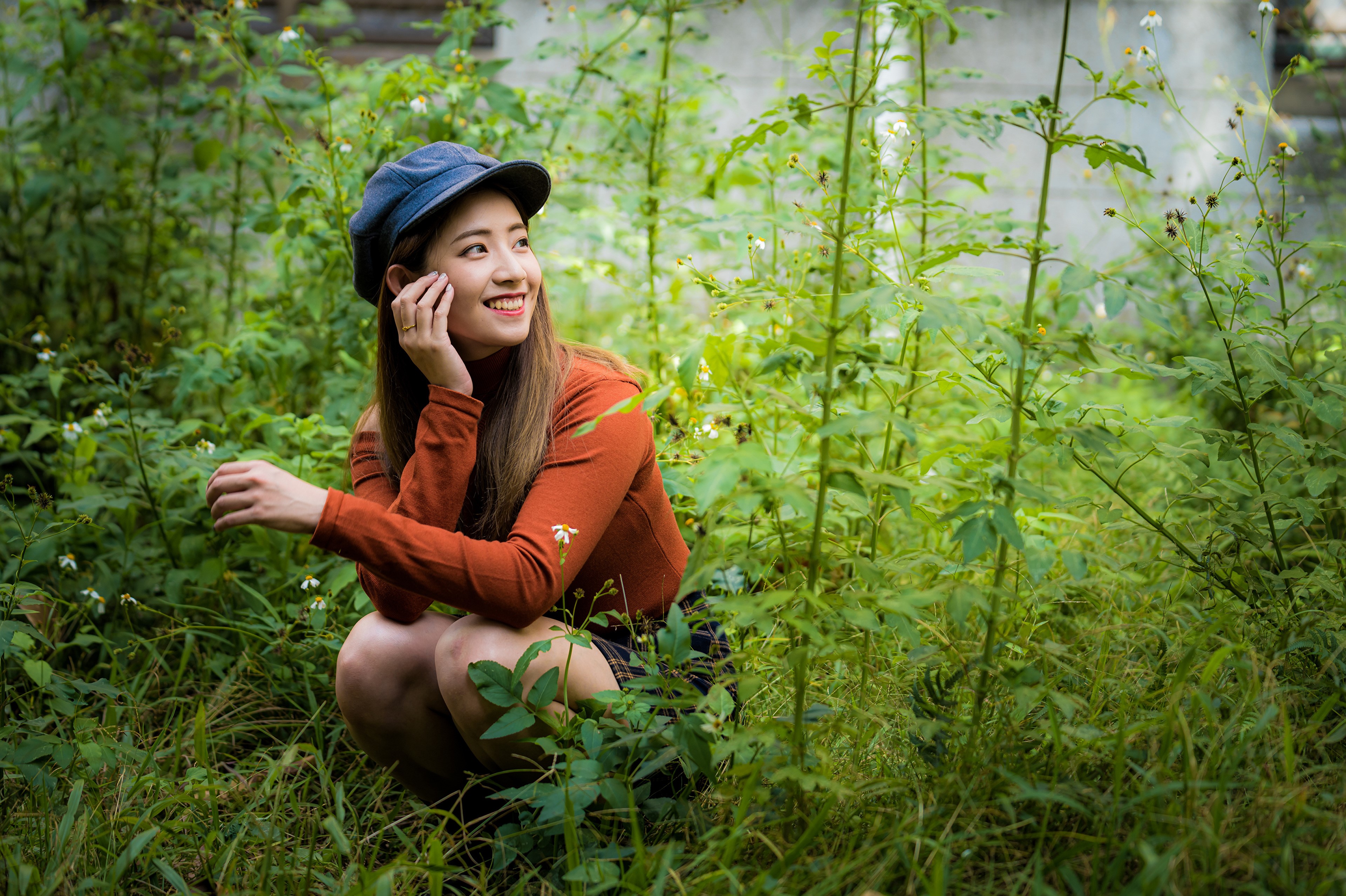 Asian woman wearing a baseball cap and sweater in grass HD Wallpaper