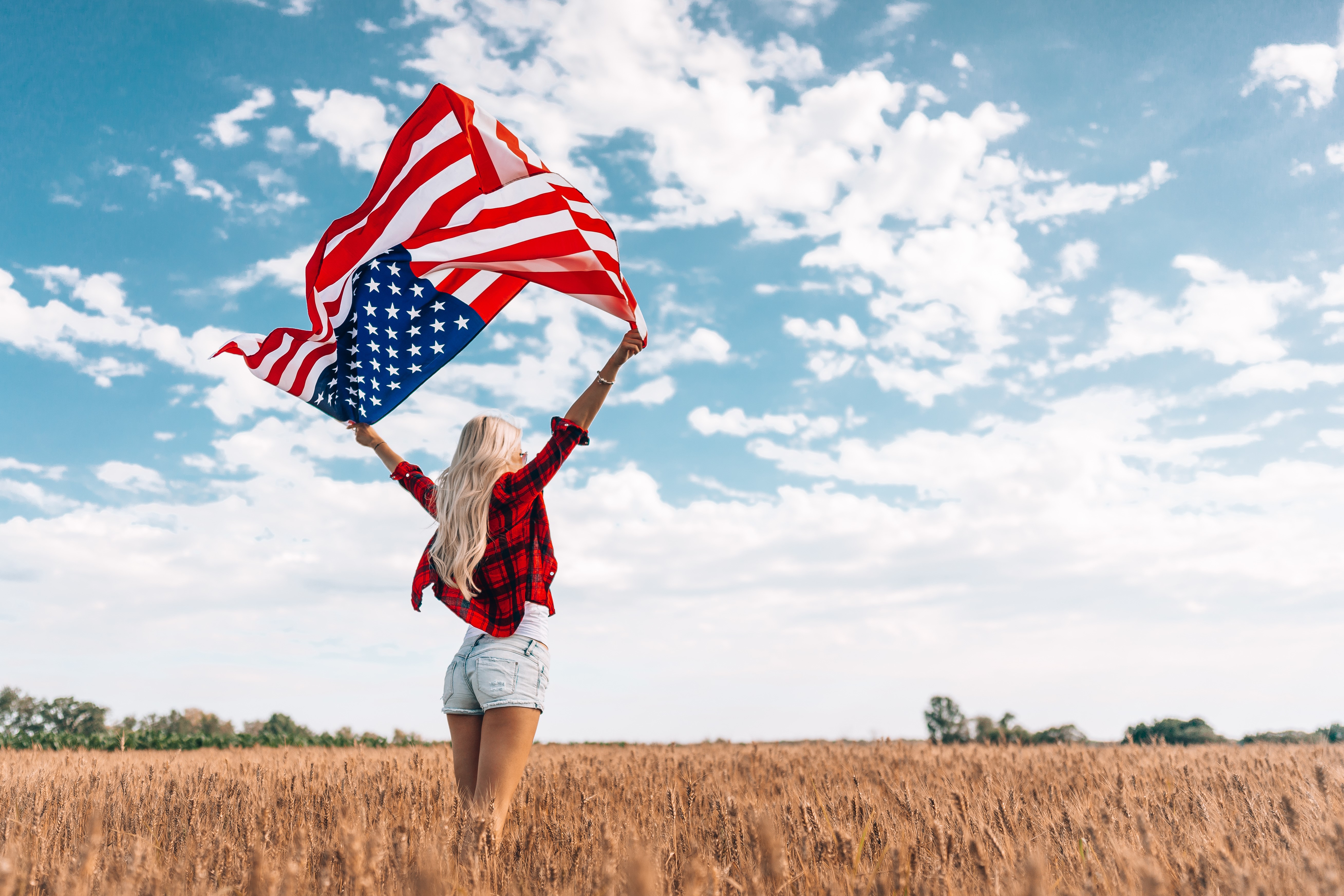 Blonde girl holding USA flag in field HD Wallpaper