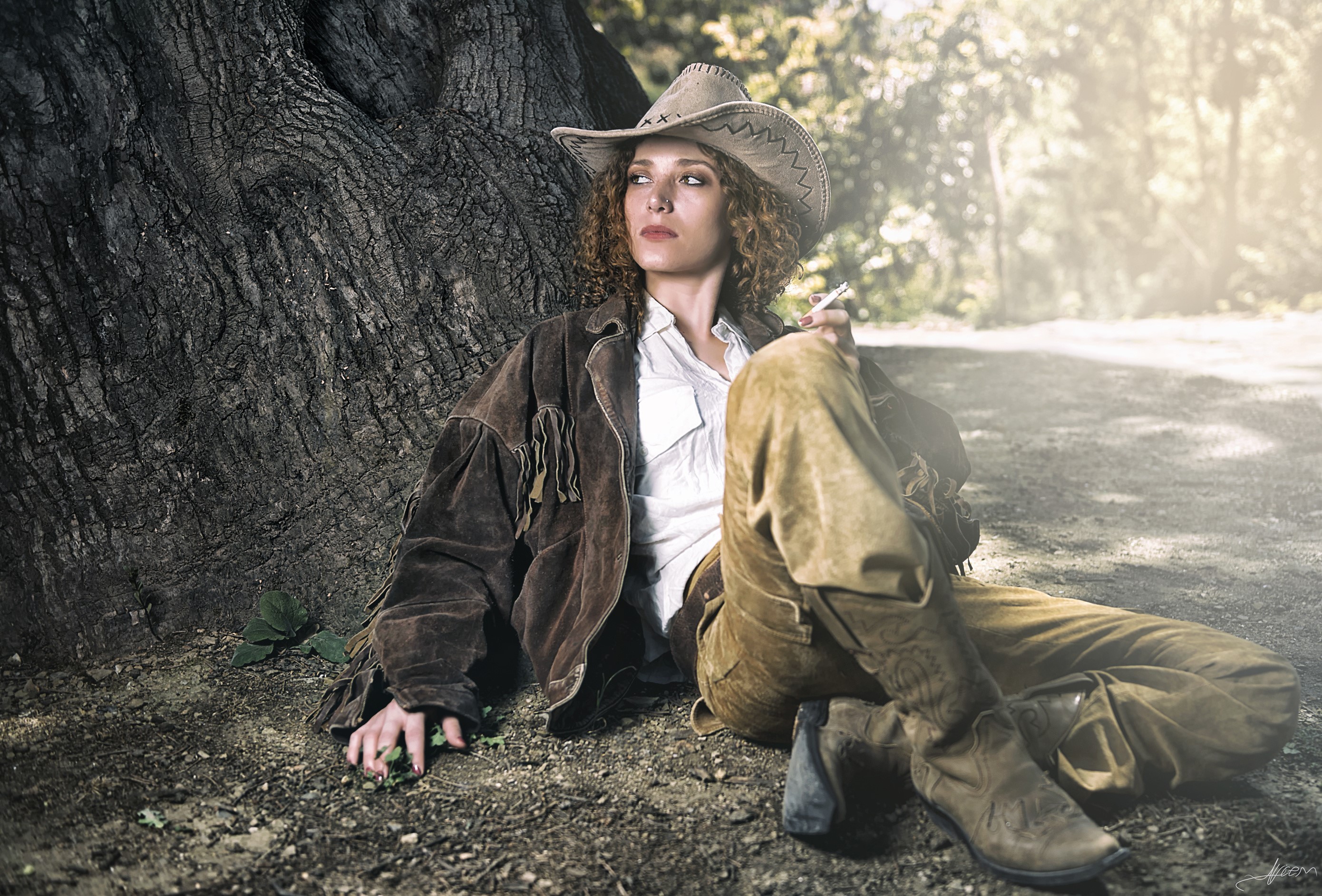 Woman in cowboy hat and jacket sitting by tree HD Wallpaper