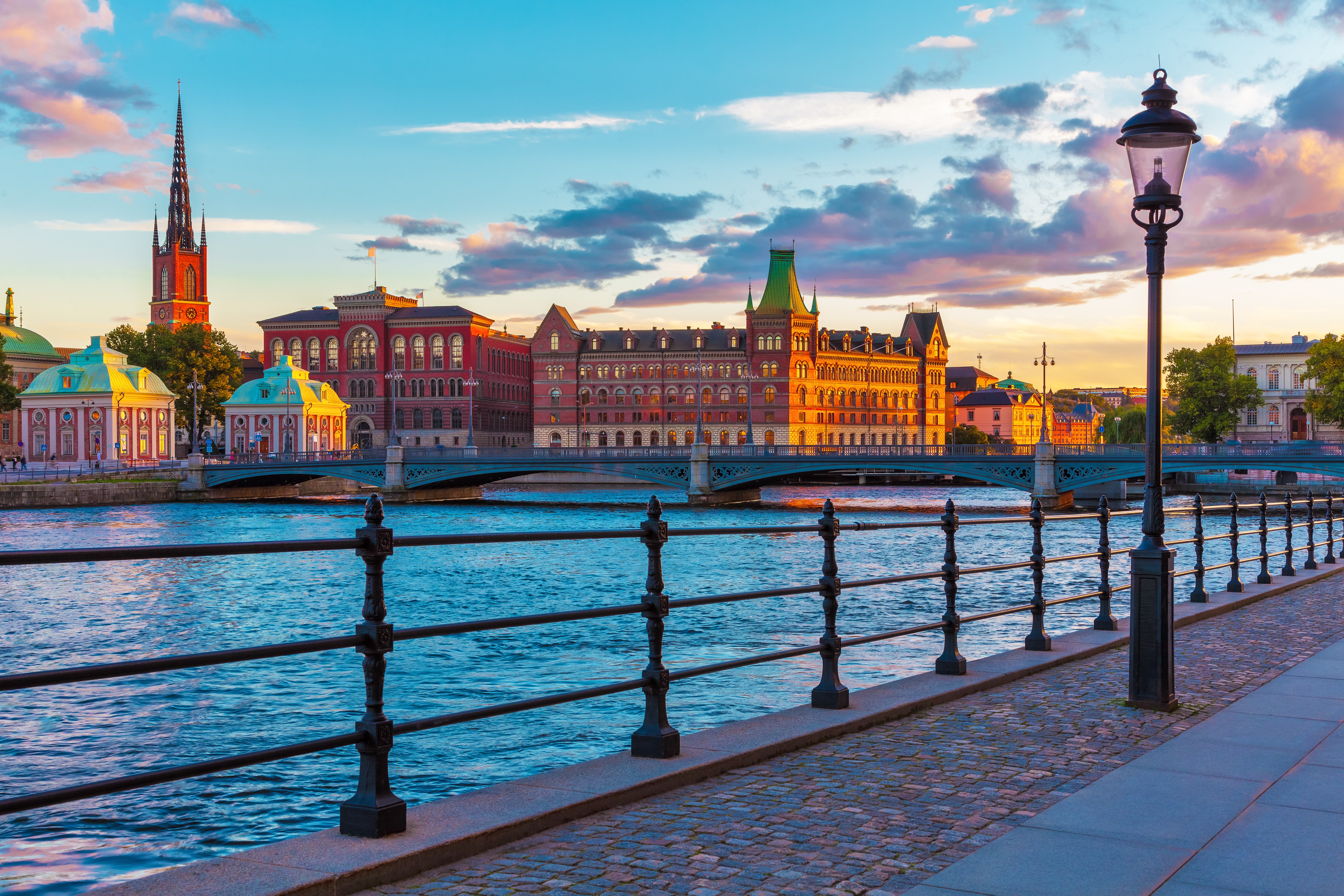 Stockholm, Sweden waterfront at sunset with bridge and buildings HD Wallpaper