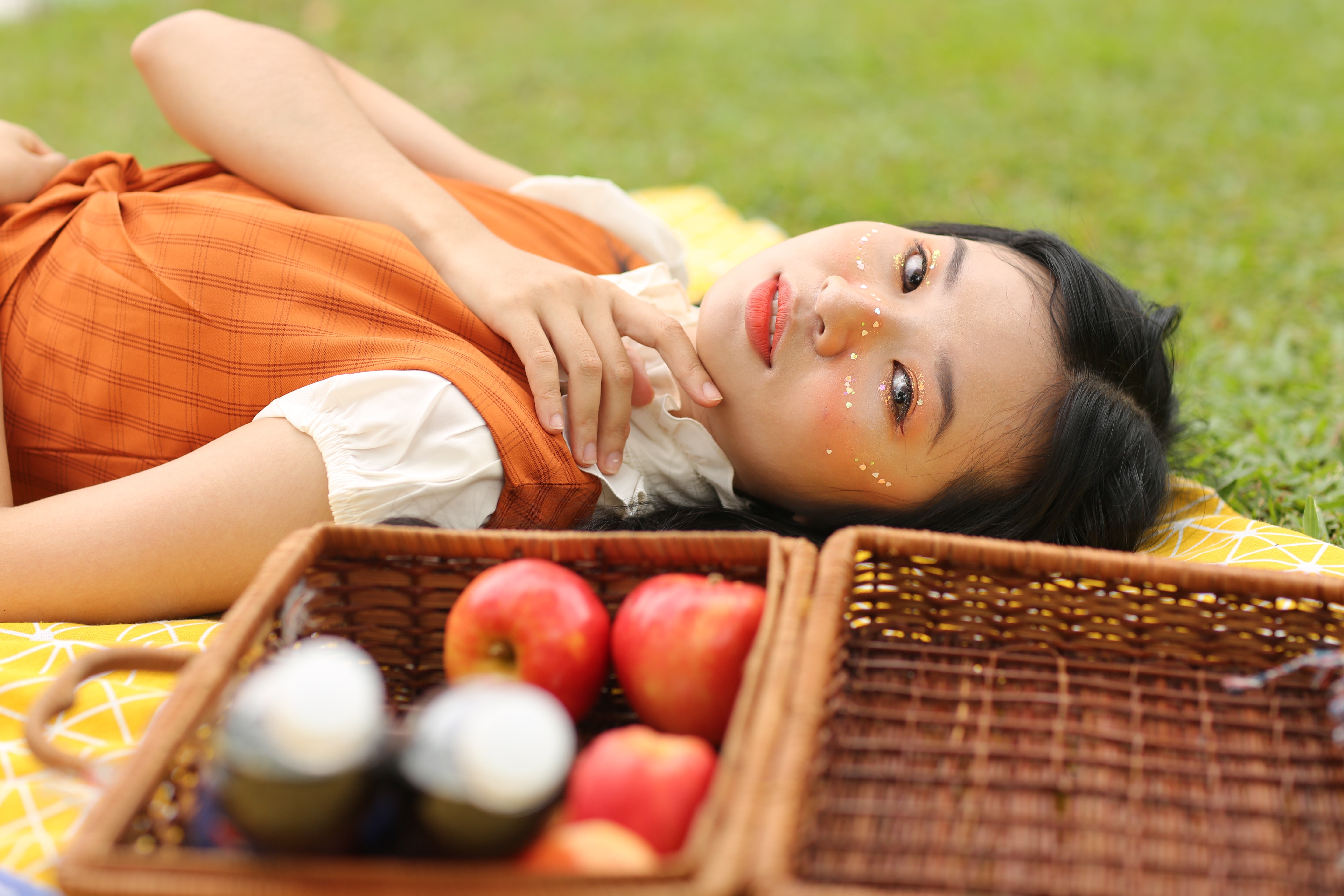 Brunette girl lying down with apples in a basket HD Wallpaper