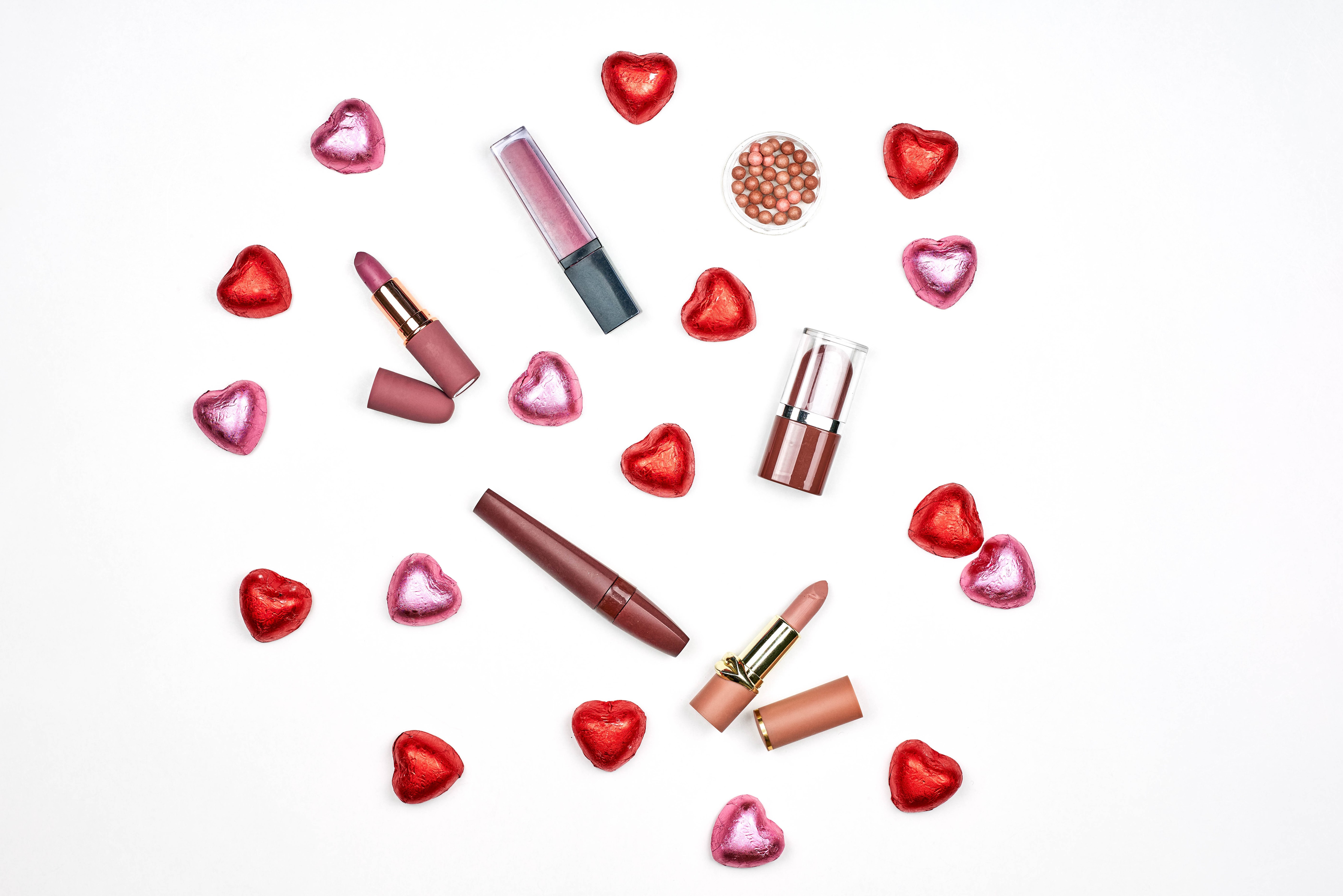 Lipsticks and heart candies on white background HD Wallpaper