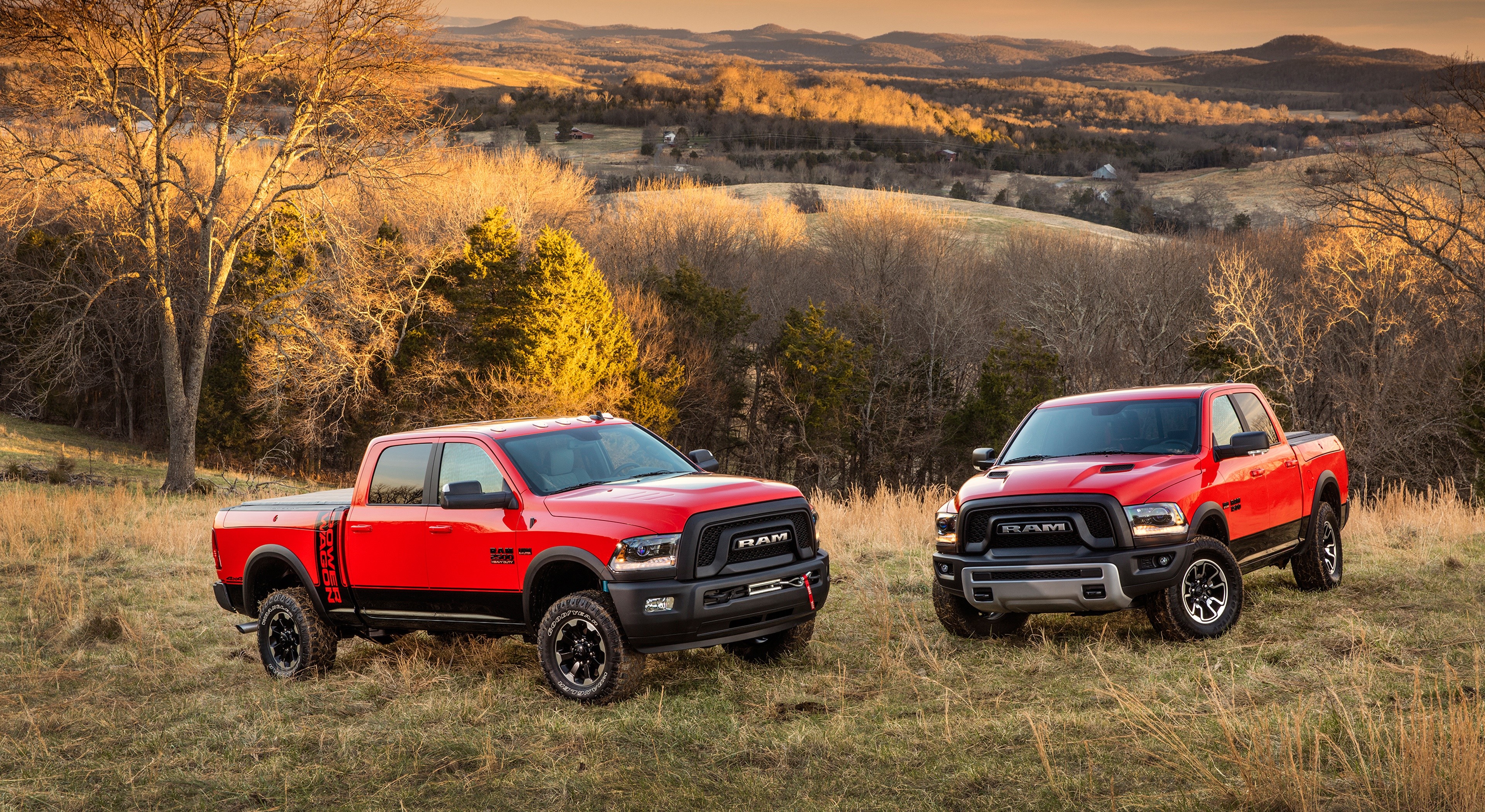 Two red Ram Power Wagon pickup trucks in a field HD Wallpaper