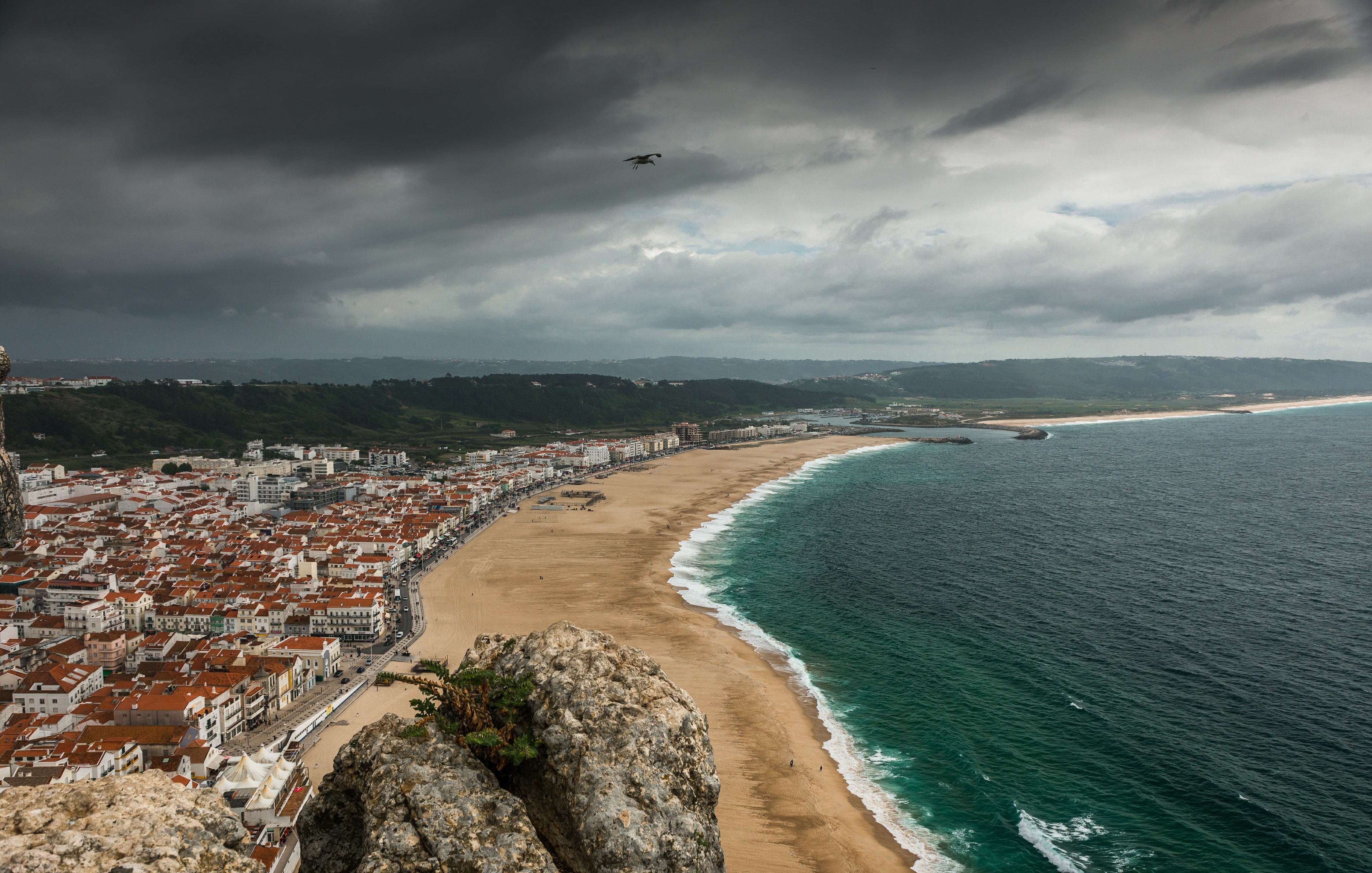 Nazare beach and town from above under stormy clouds HD Wallpaper