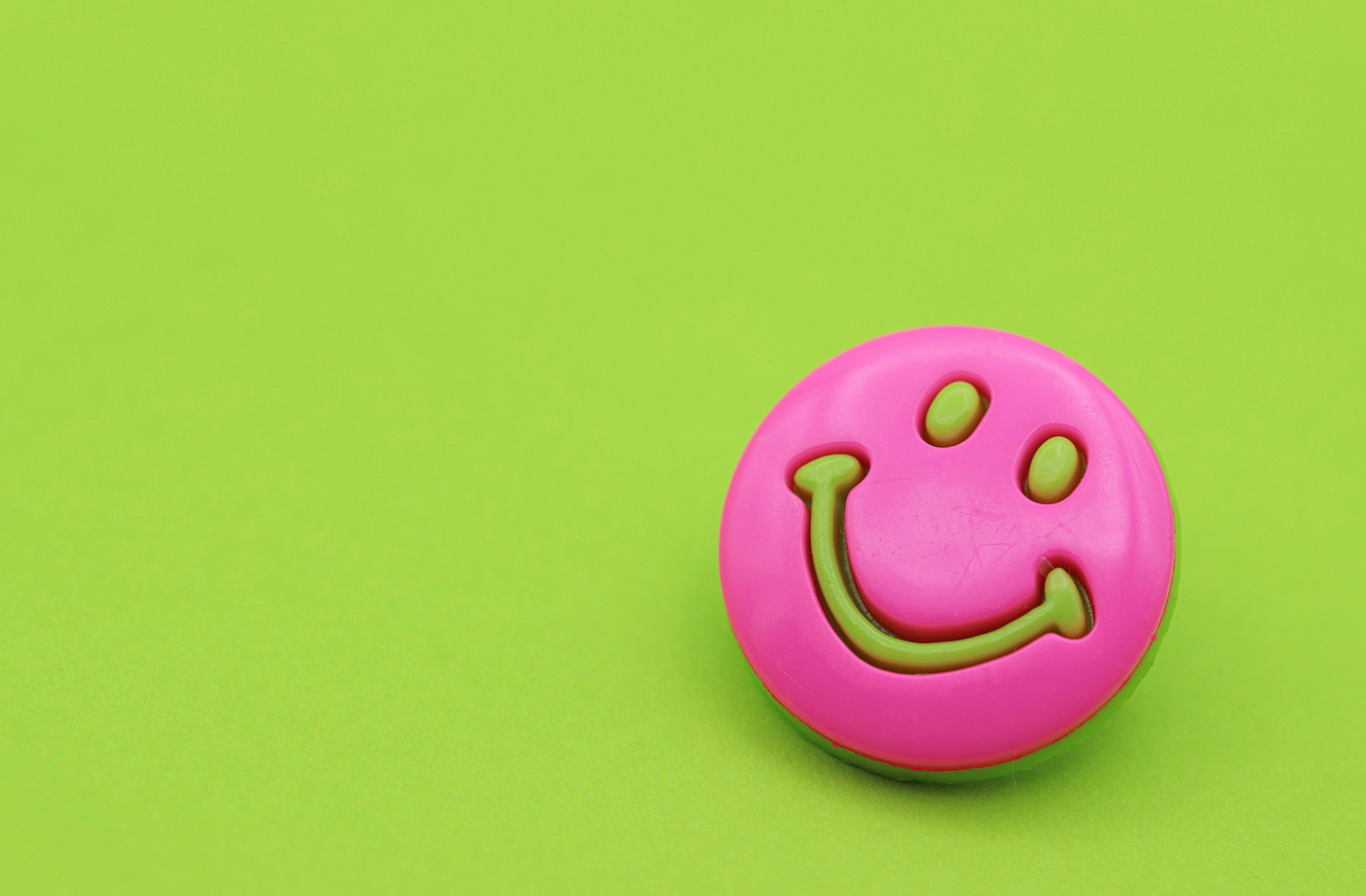 Pink and green smiley face on a lime green background HD Wallpaper