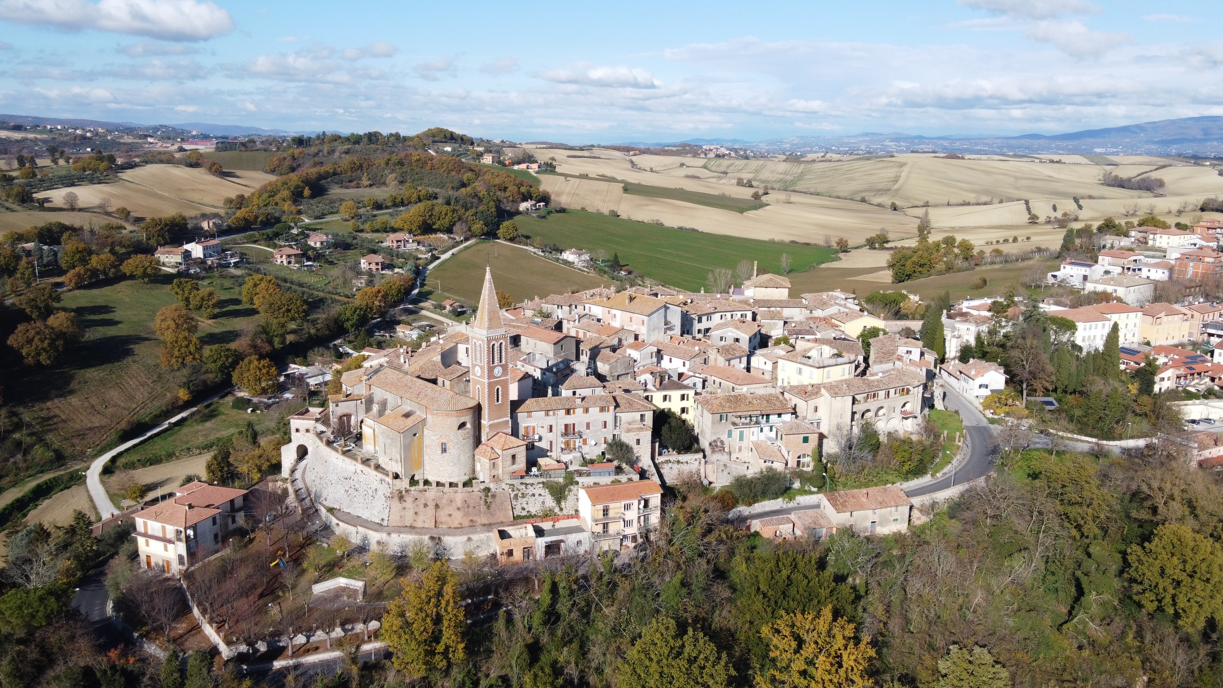 Aerial view of a medieval Italian town with a church tower HD Wallpaper