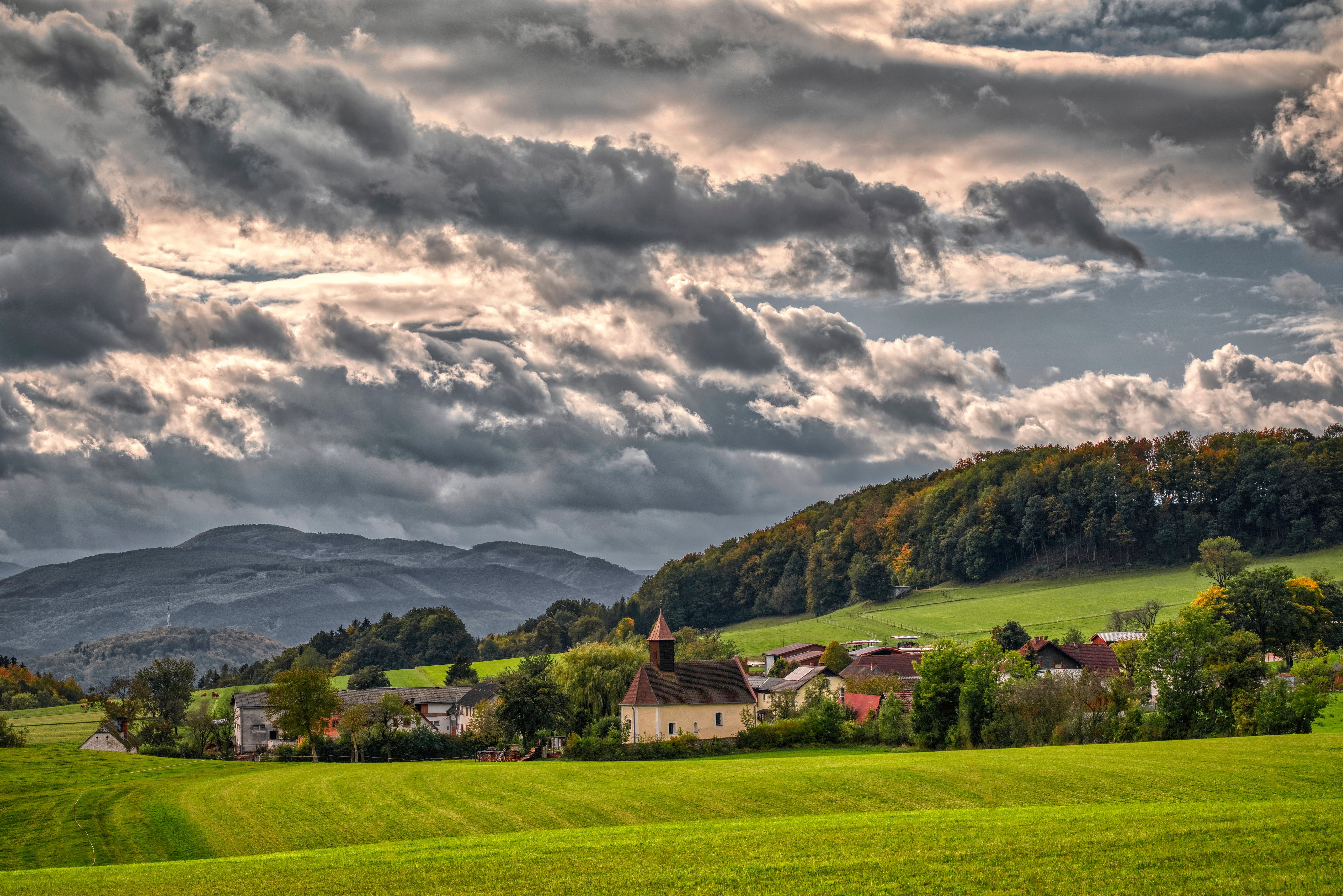 Village with church in Upper Austria with mountains and clouds HD Wallpaper