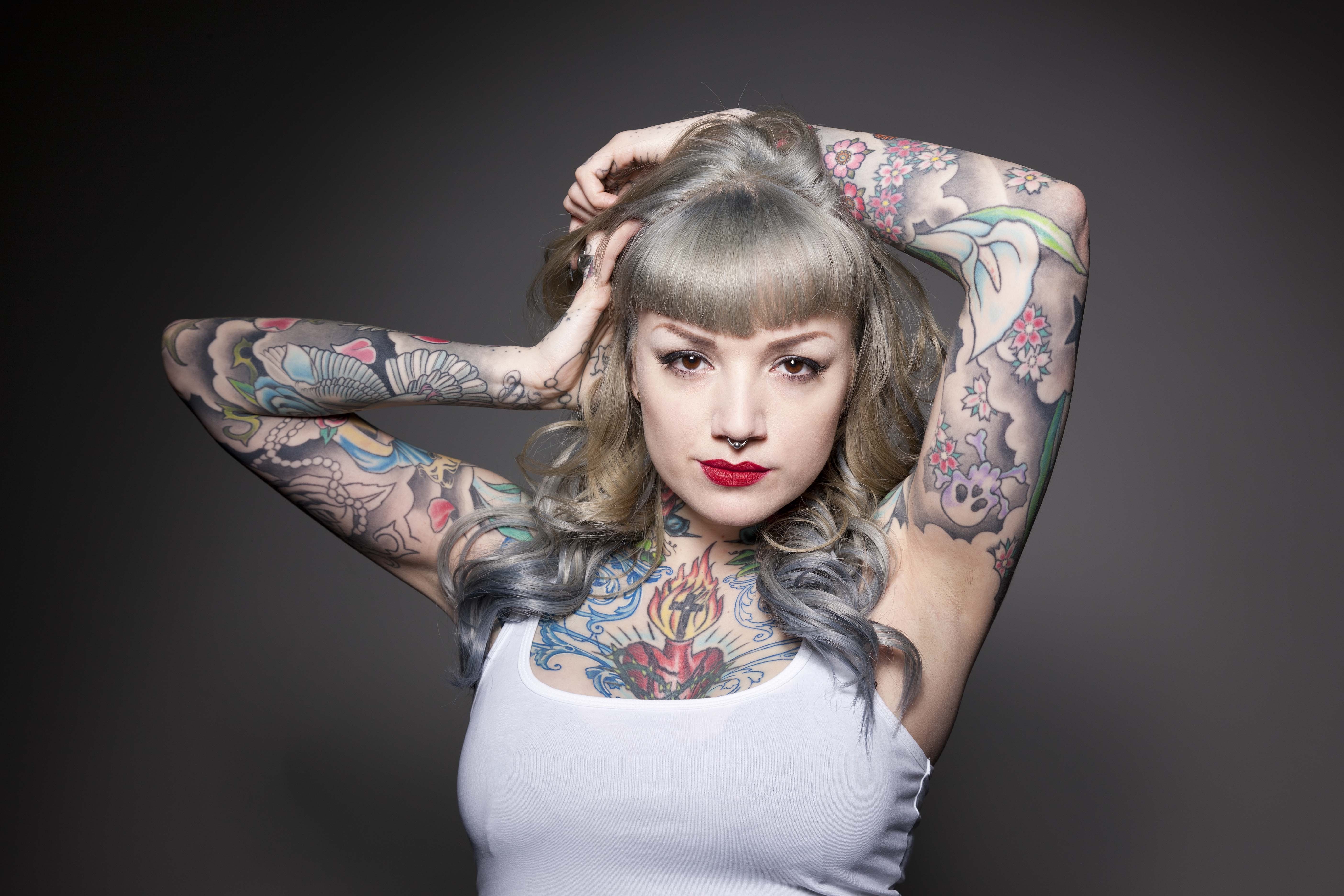 Woman with tattoos and piercings on gray background HD Wallpaper