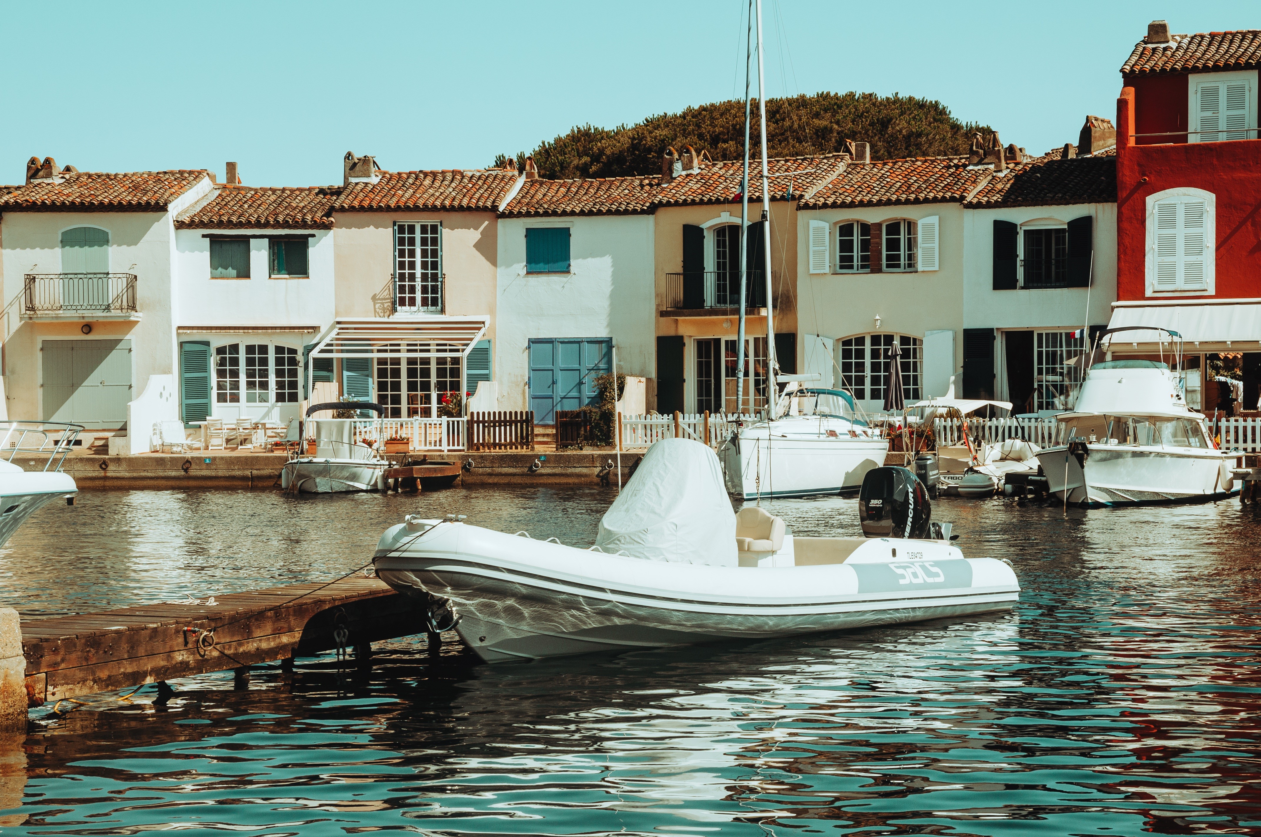 Boats docked in front of colorful houses in Saint-Tropez, France HD Wallpaper
