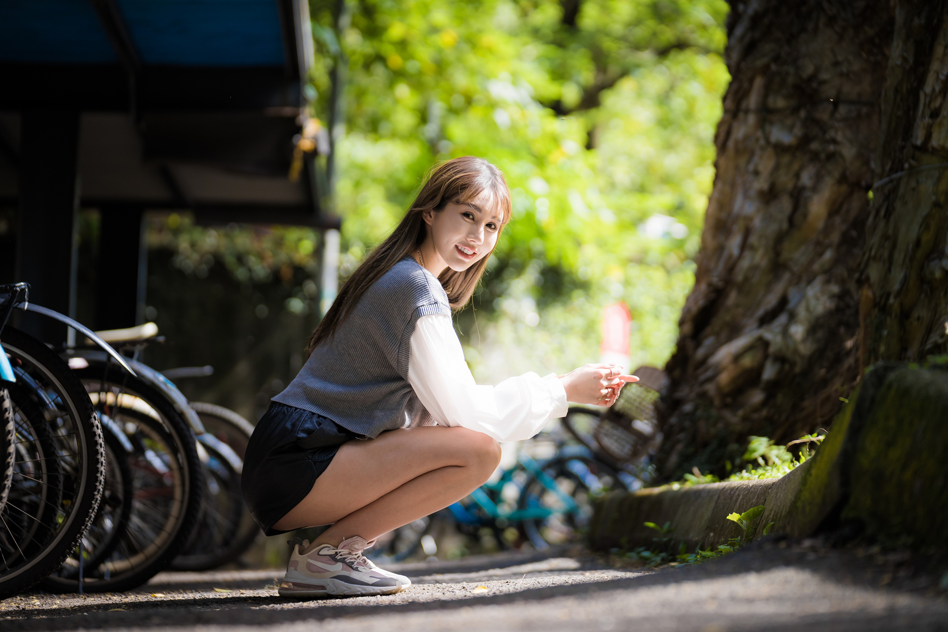 Asian woman posing near bicycles and a tree HD Wallpaper