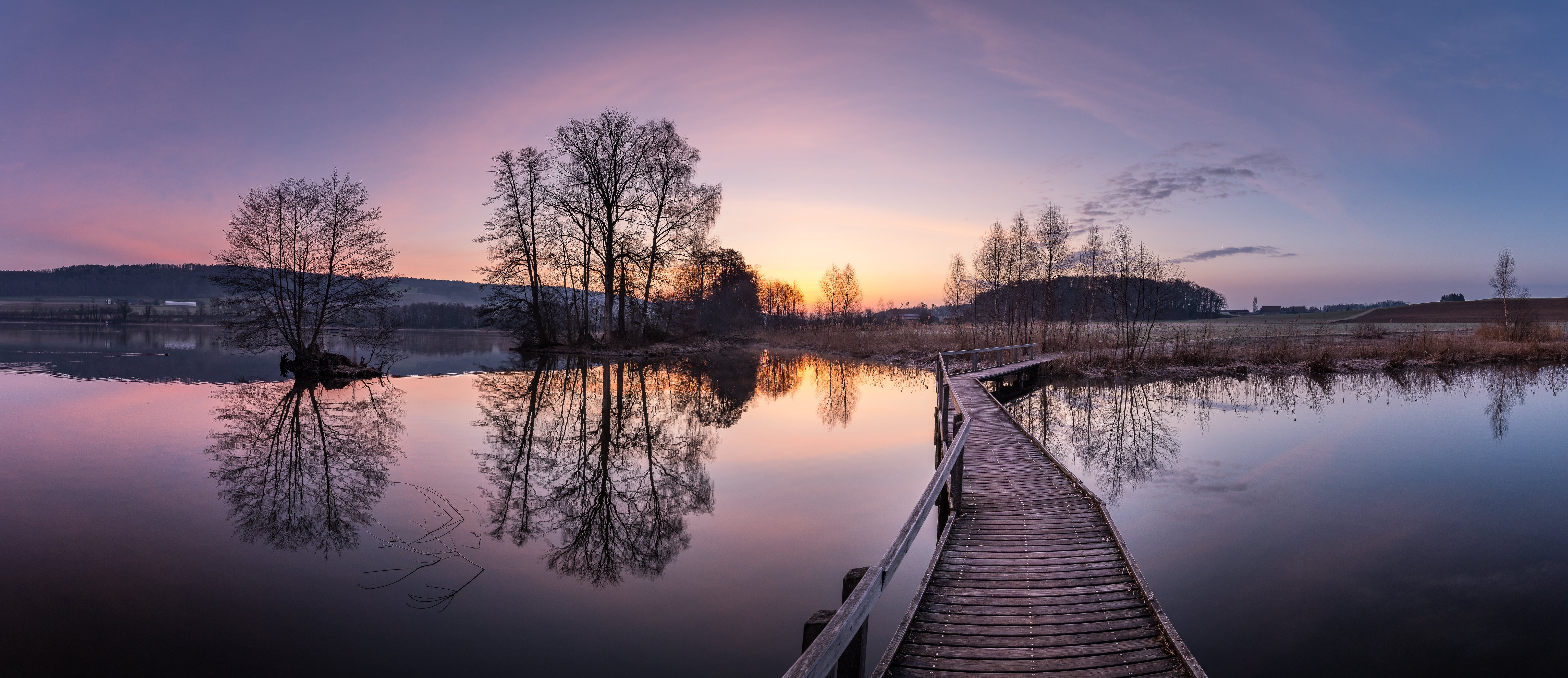 Wooden bridge over lake at sunrise with trees and reflections HD Wallpaper