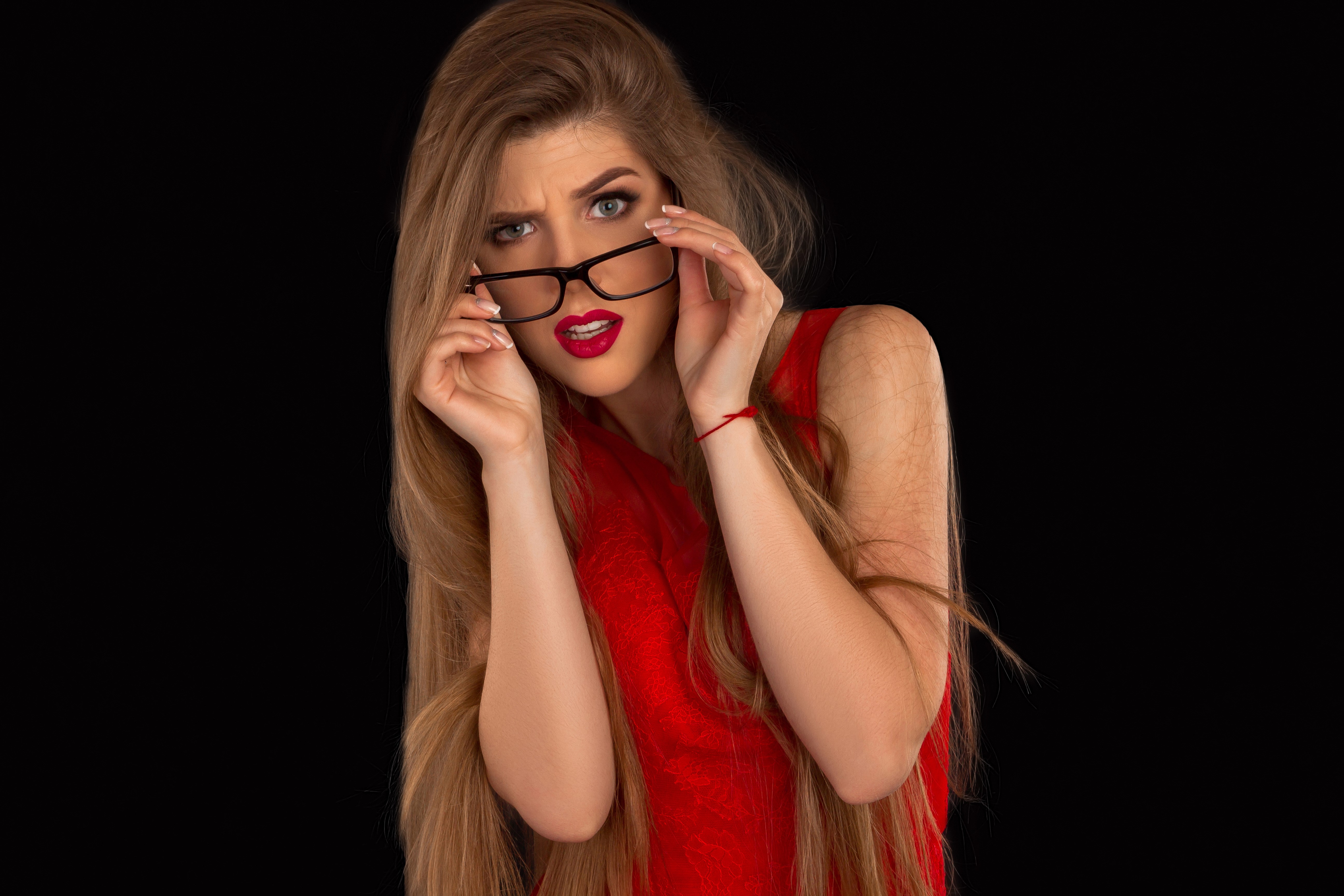 Woman with glasses and red dress on black background HD Wallpaper