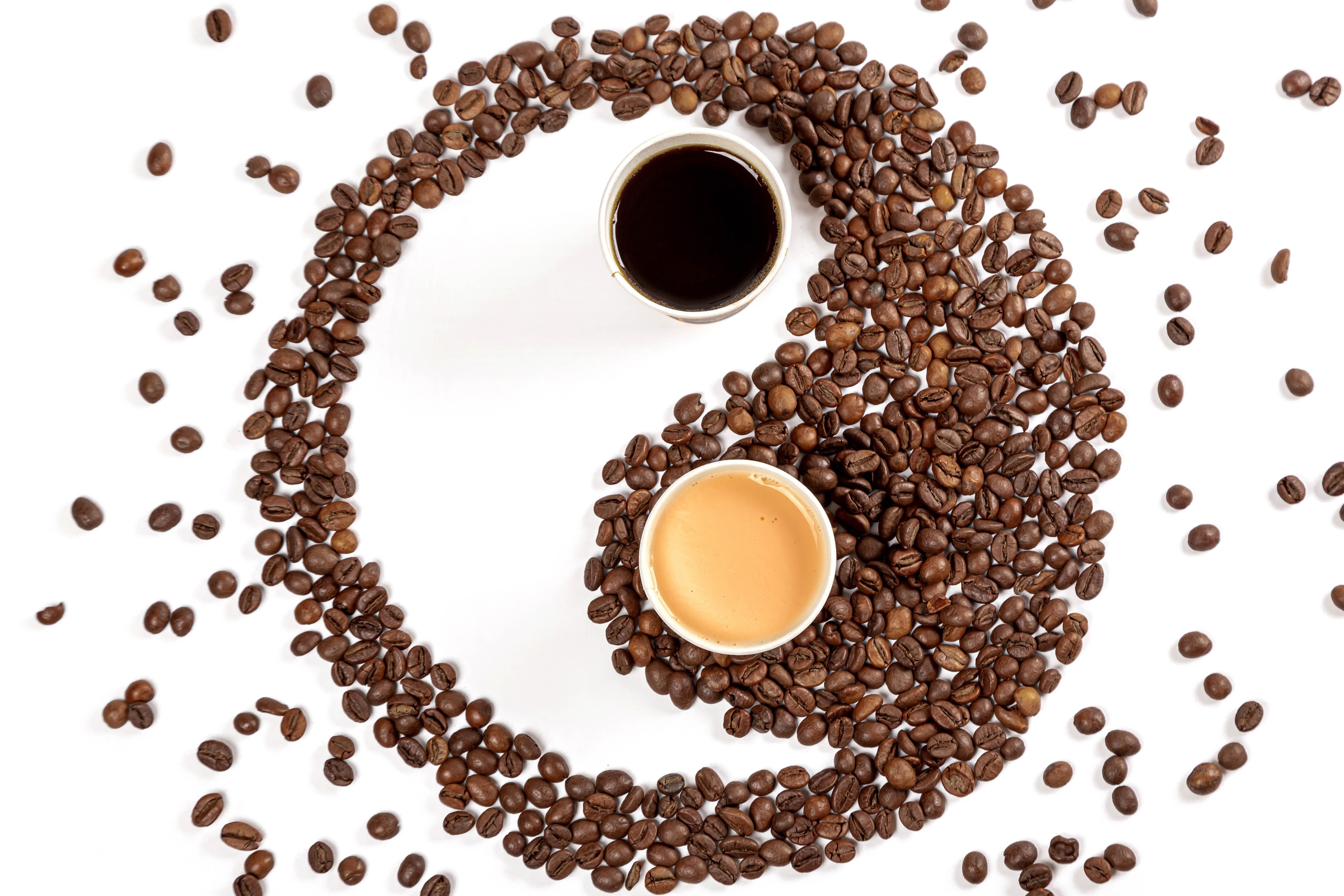 Coffee beans arranged in Yin-Yang symbol with two cups of coffee HD Wallpaper