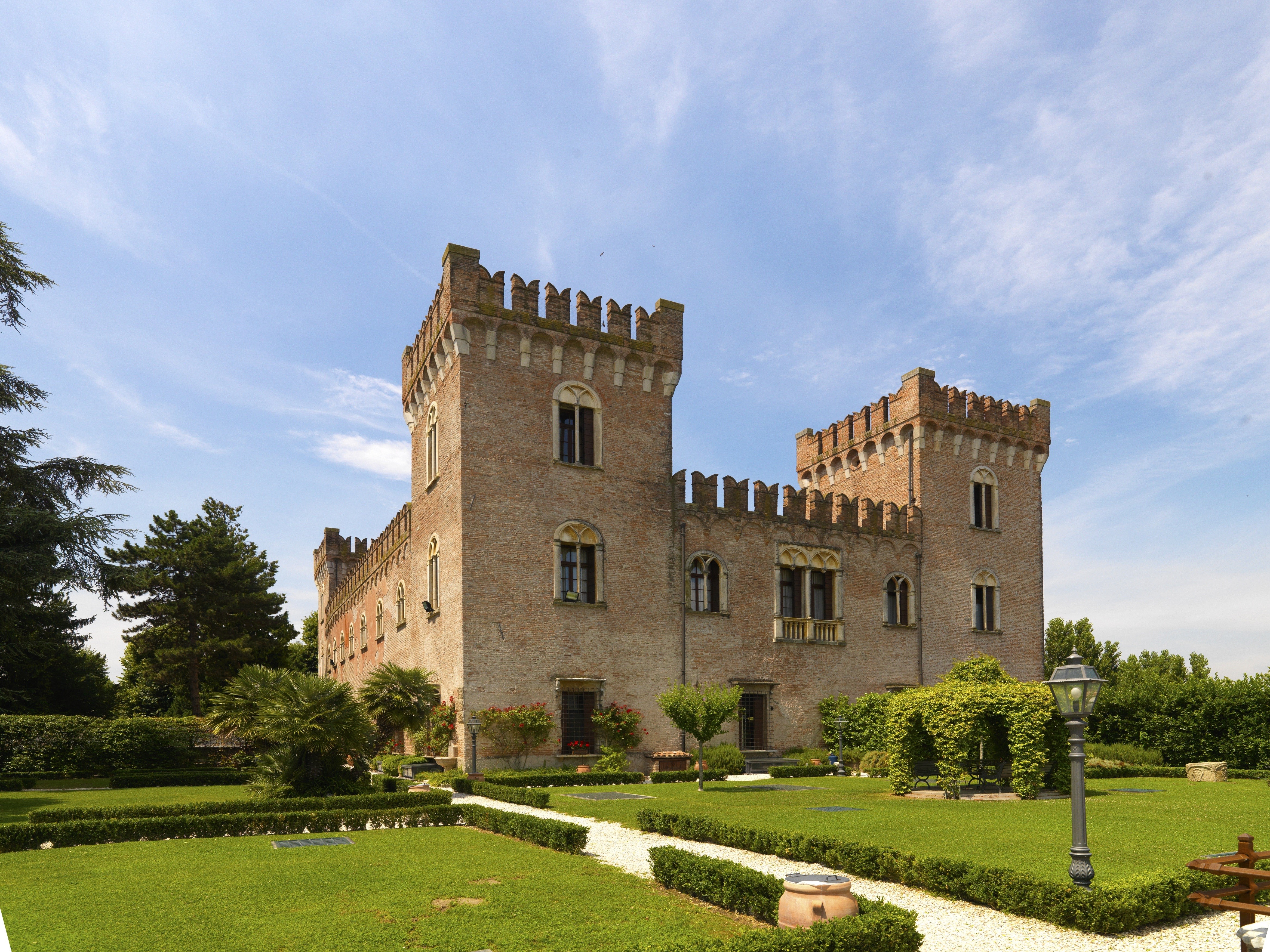 Castle with crenellated towers and manicured gardens HD Wallpaper